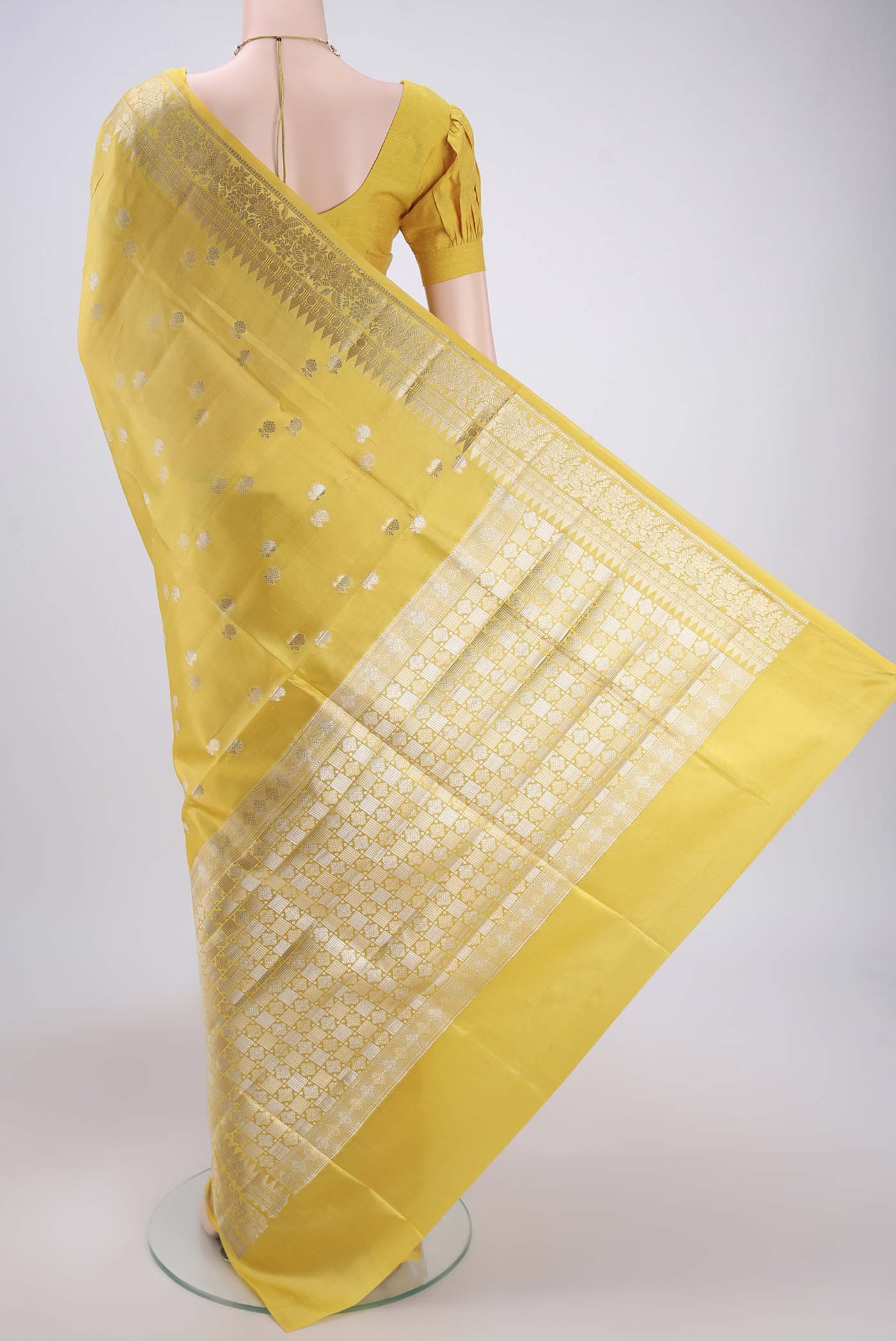 Flat view of Lemon Yellow Banarasi Raw Silk Saree with Zari Butta on the body and Zari Border. 