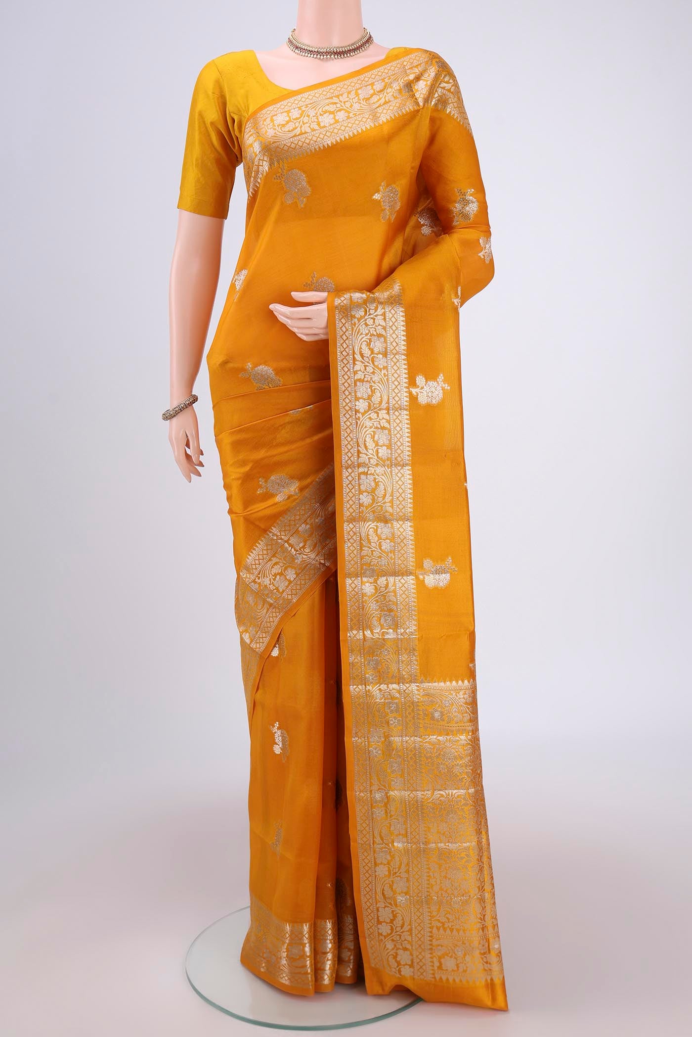 Yellow Banarasi Raw Silk Saree with Zari Butta on the body and Zari Border.  displayed on a mannequin
