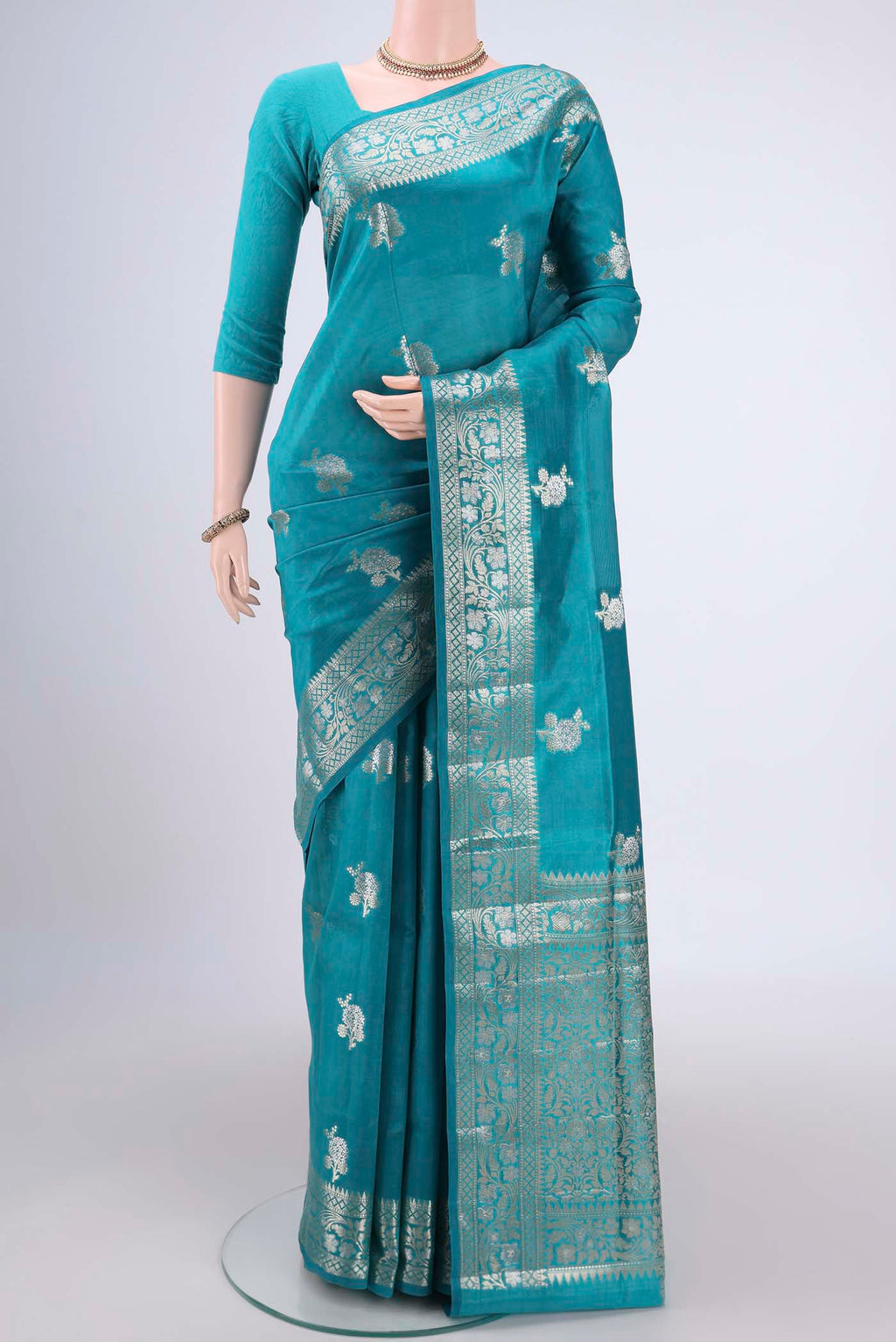 Teal Banarasi Raw Silk Saree with Zari Butta on the body and Zari Border.  displayed on a mannequin