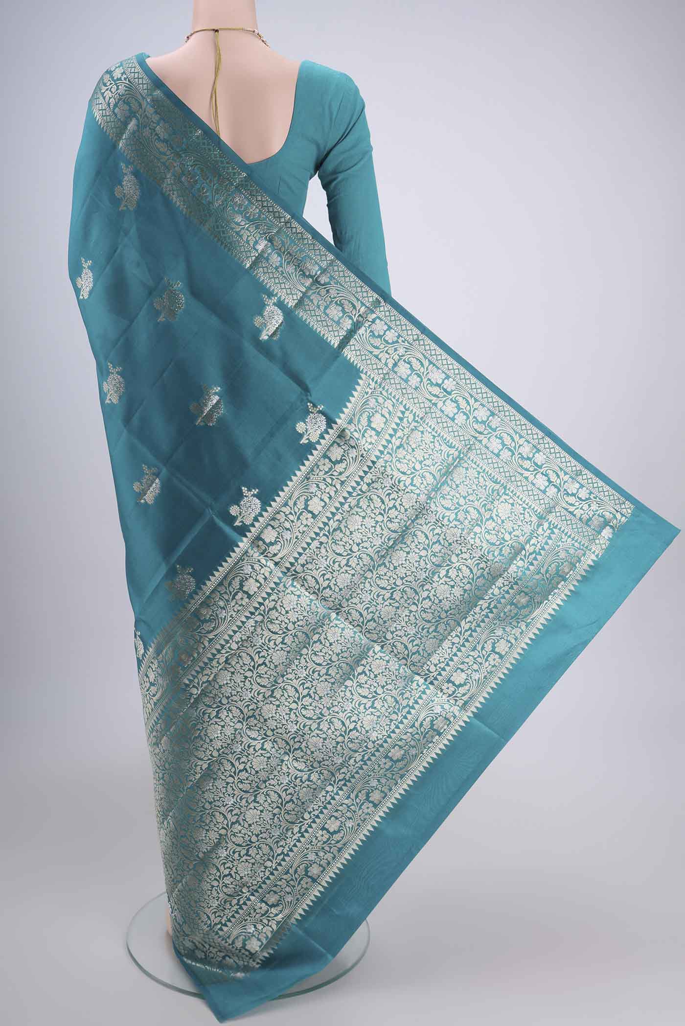 Flat view of Teal Banarasi Raw Silk Saree with Zari Butta on the body and Zari Border. 