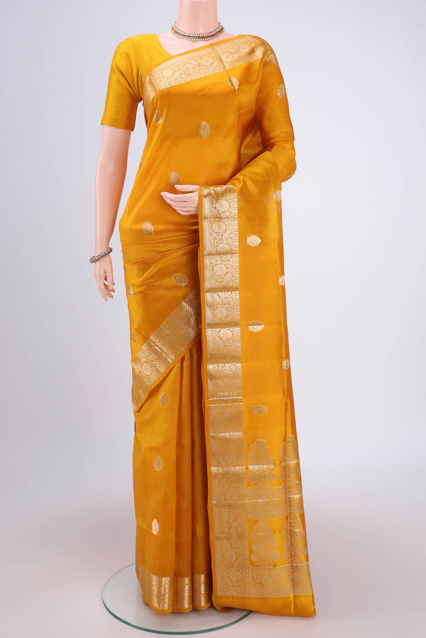 Yellow Banarasi Raw Silk Saree with Zari Butta on the body and Zari Border.  displayed on a mannequin