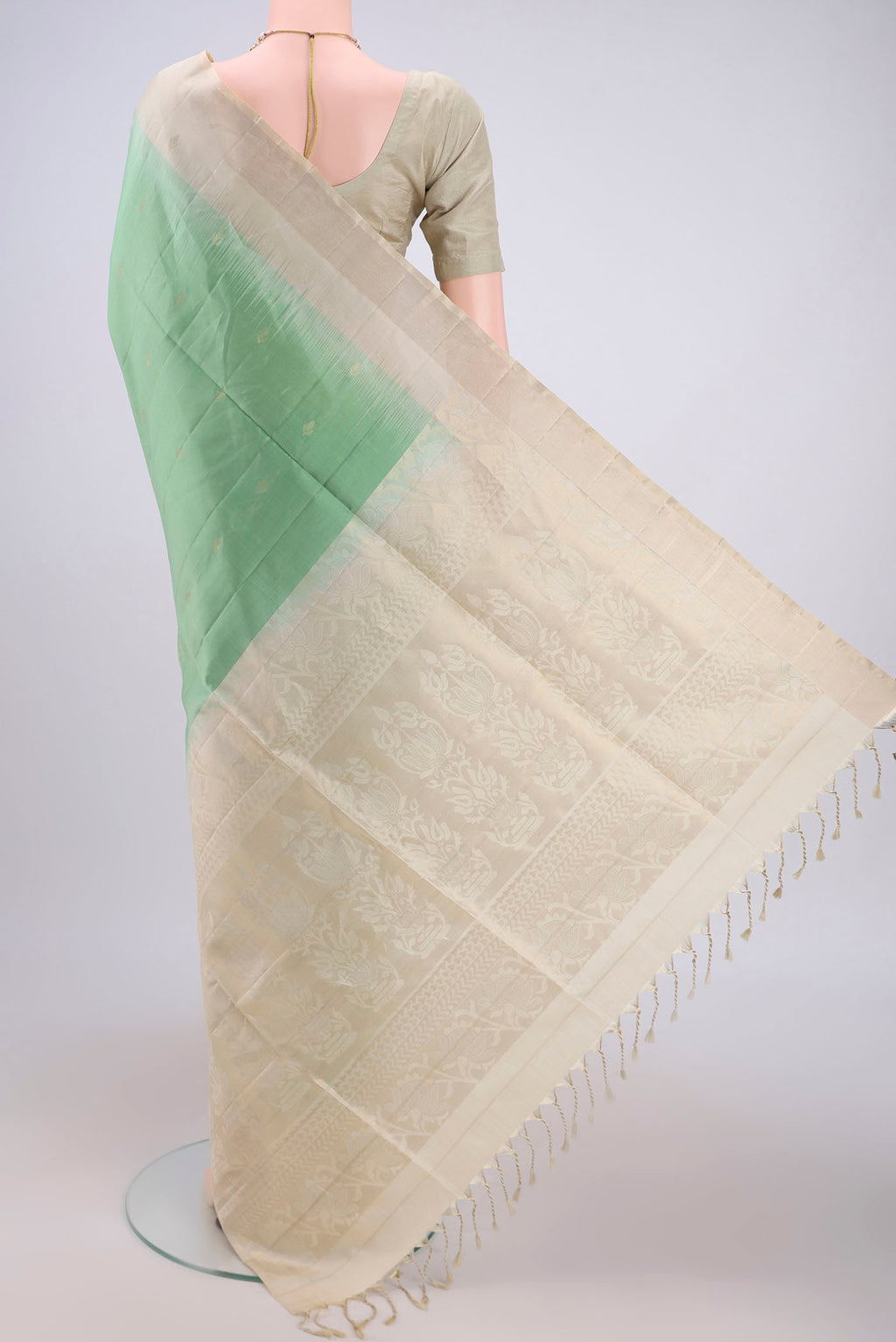 Flat view of Light Green Soft Silk Saree with Zari Butta on the body and Zari Border. 