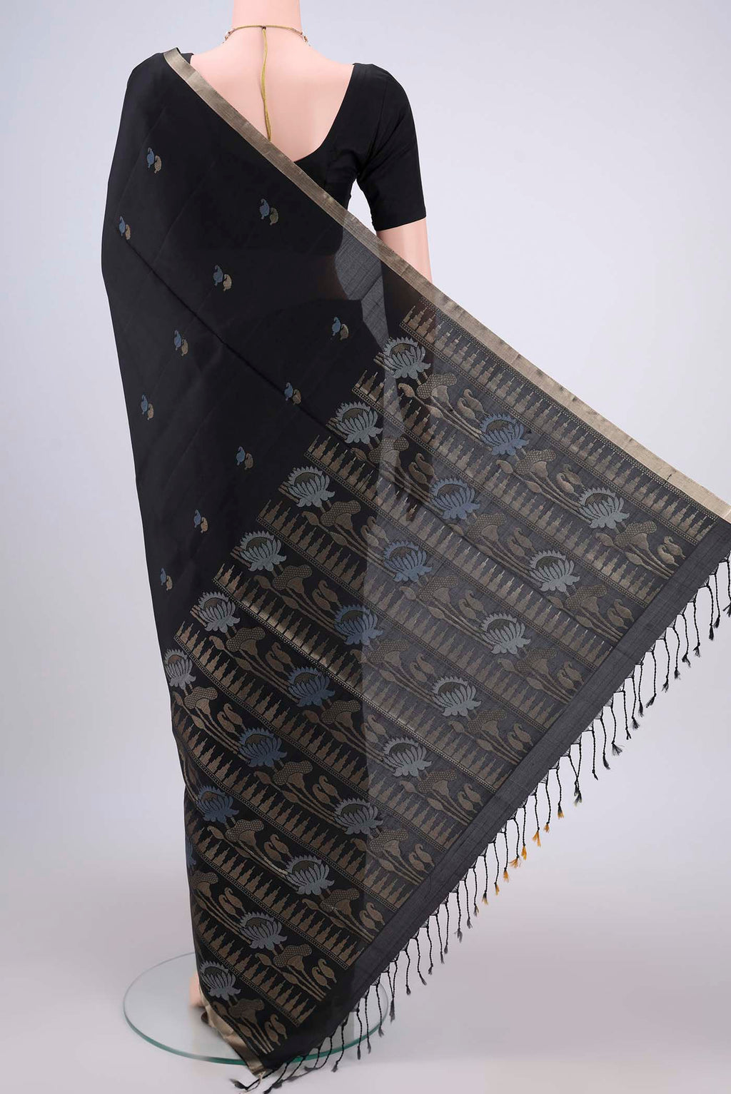 Flat view of Black Baluchari Silk Saree with Zari And Thread Butta on the body and Zari Border. 
