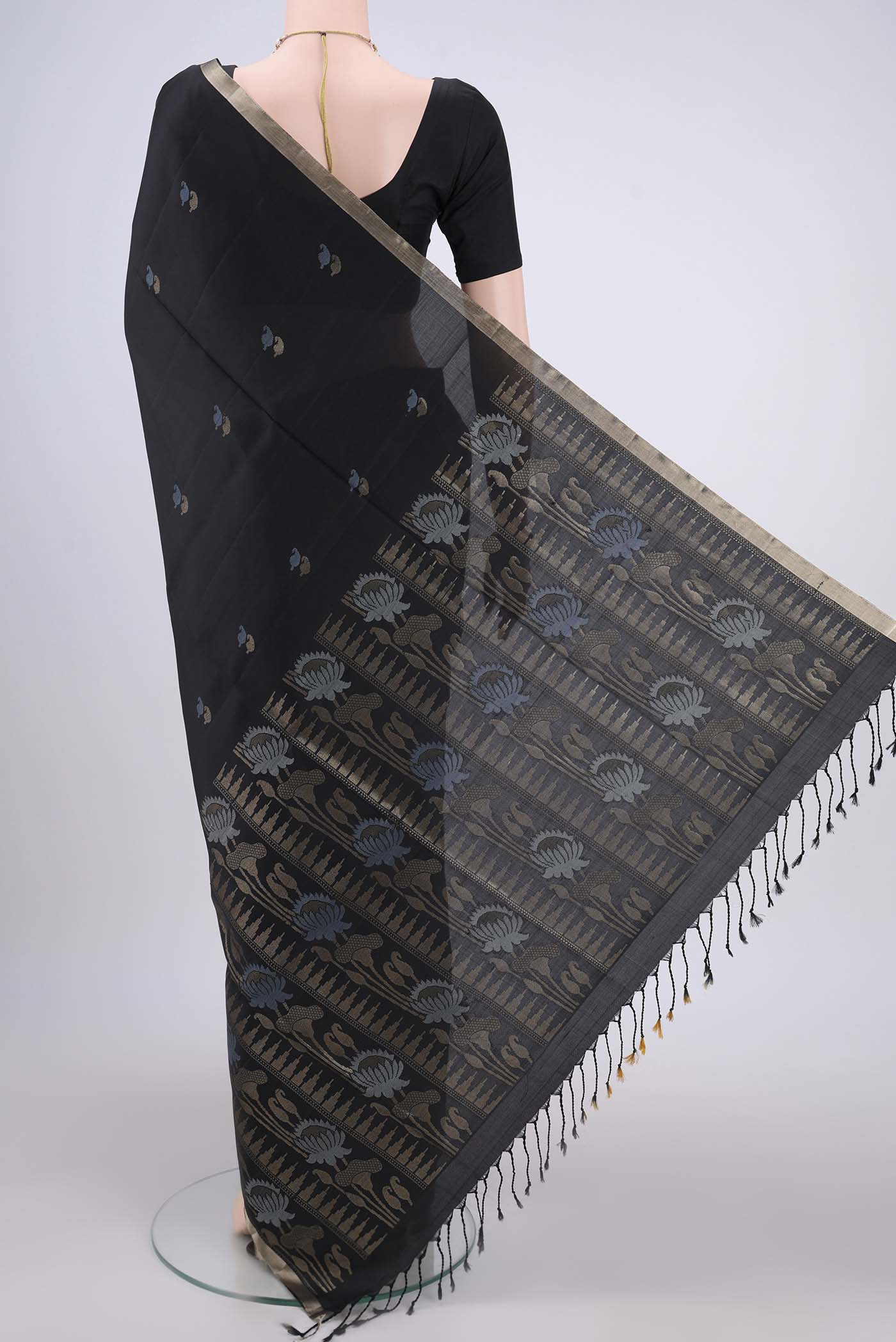 Flat view of Black Baluchari Silk Saree with Zari And Thread Butta on the body and Zari Border. 