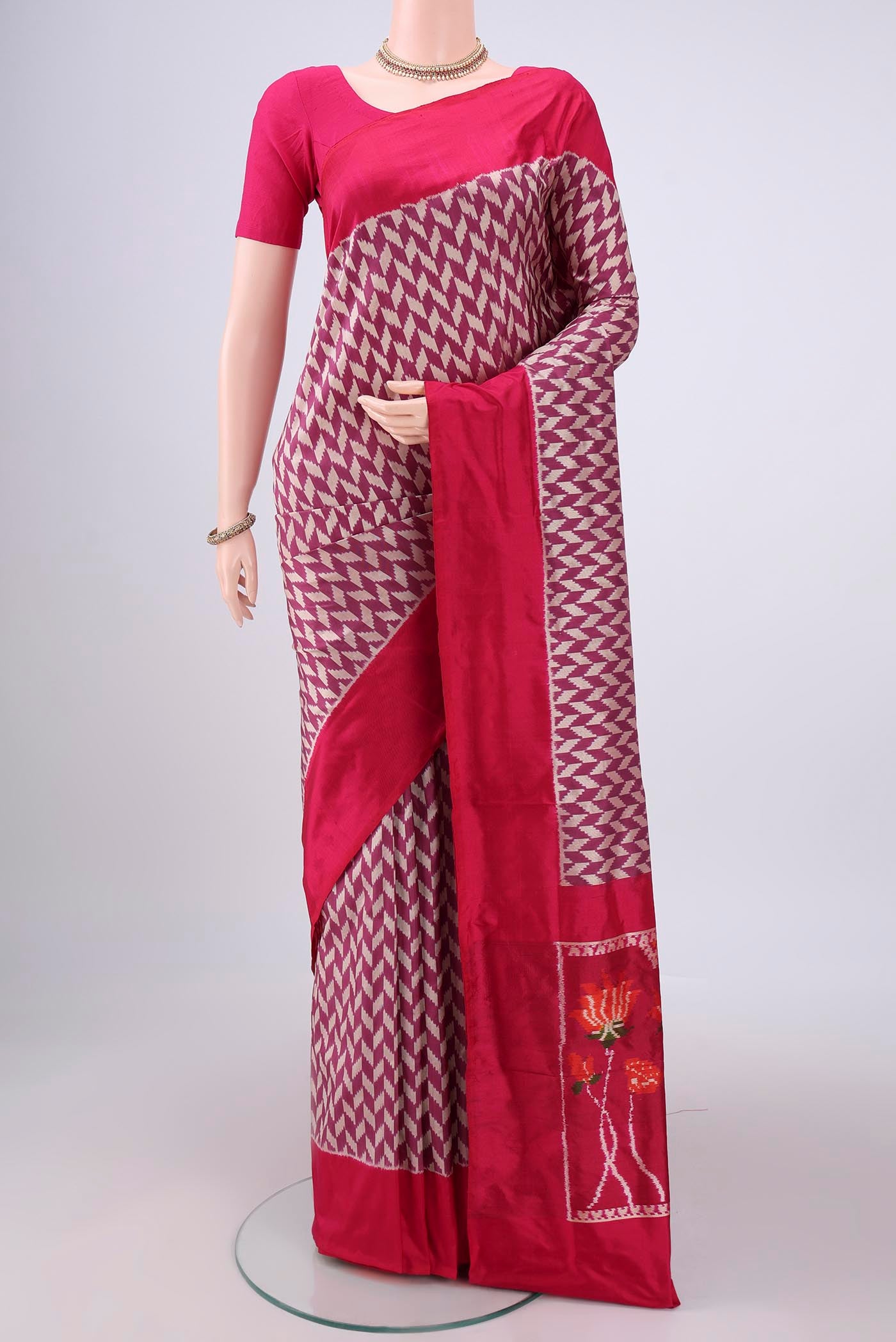 Magenta Pochampally Silk Saree with Ikat design on the body and Zari Border.  displayed on a mannequin