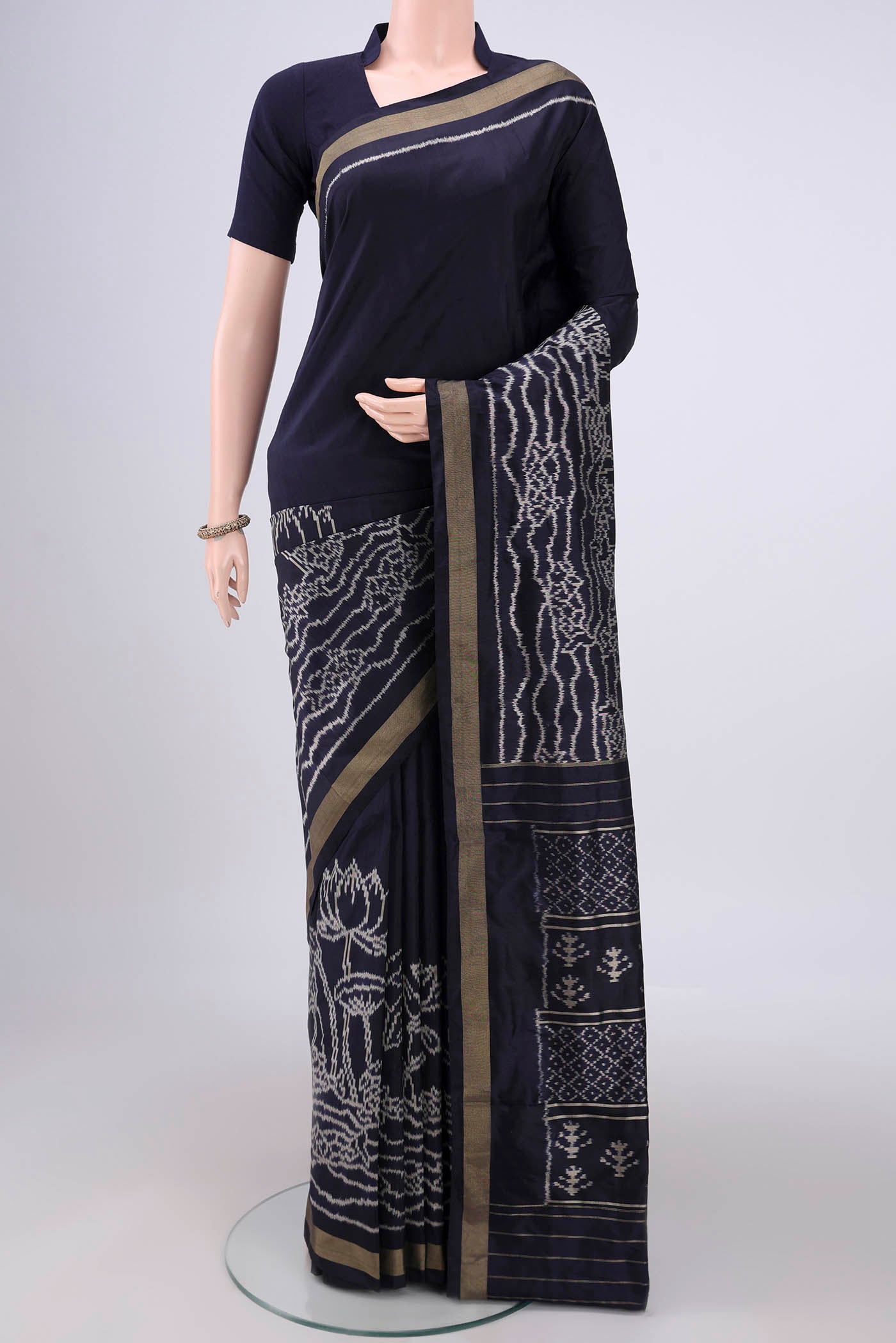 Navy Blue Pochampally Silk Saree with Ikat design on the body and Zari Border.  displayed on a mannequin