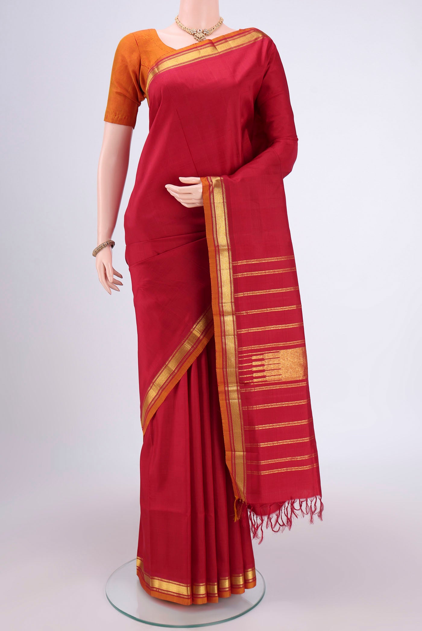 Red Kanjivaram Silk Saree with Zari Butta on the body and Zari Border.  displayed on a mannequin