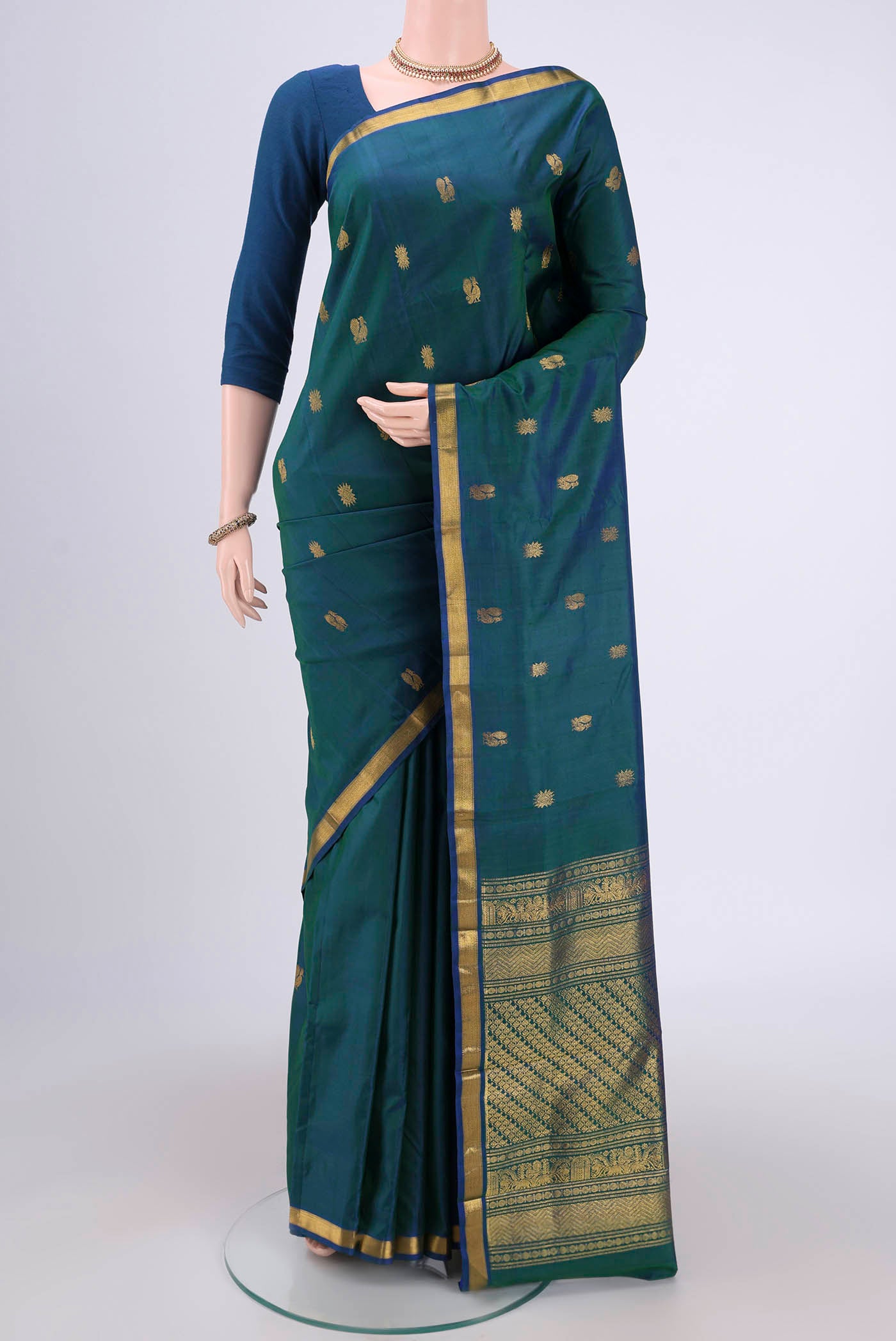 Turquoise Kanjivaram Silk Saree with Zari Butta on the body and Zari Border.  displayed on a mannequin
