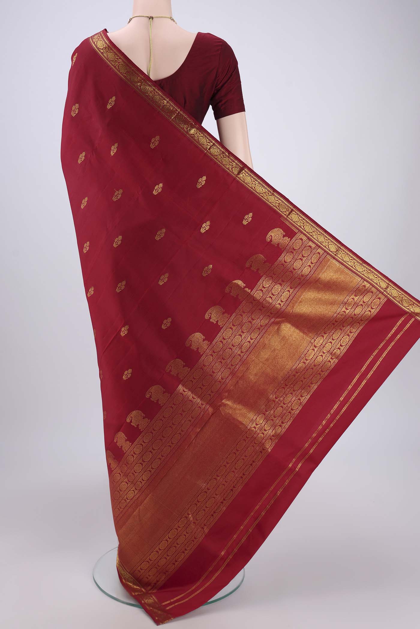 Flat view of Maroon Kanjivaram Silk Saree with Zari Butta on the body and Zari Border. 
