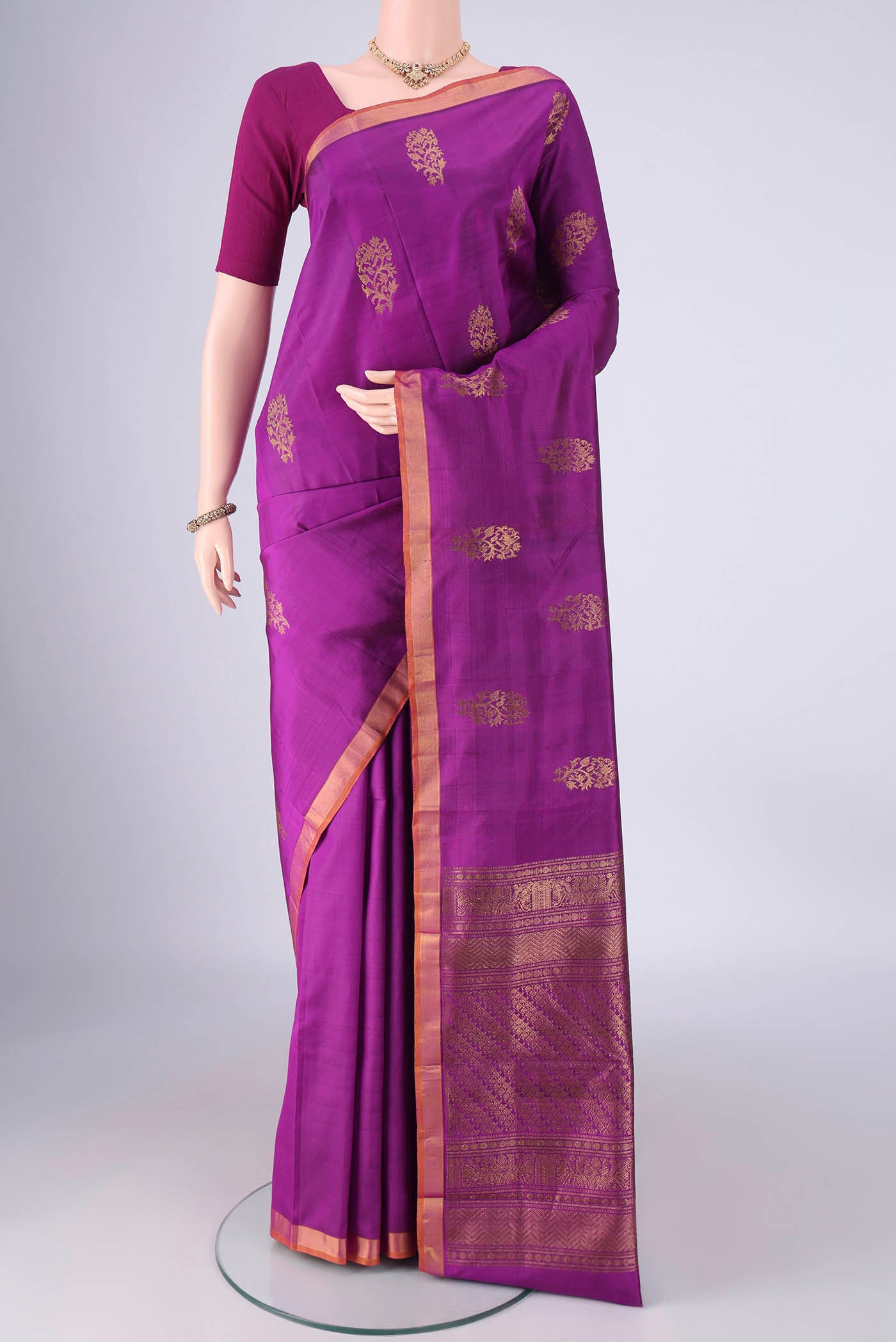 Purple Kanjivaram Silk Saree with Zari Butta on the body and Zari Border.  displayed on a mannequin
