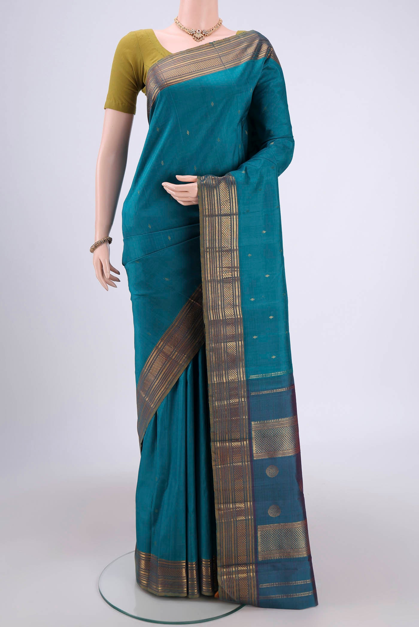 Turquoise Kanchipuram Silk Saree with Zari Butta on the body and Zari Border.  displayed on a mannequin
