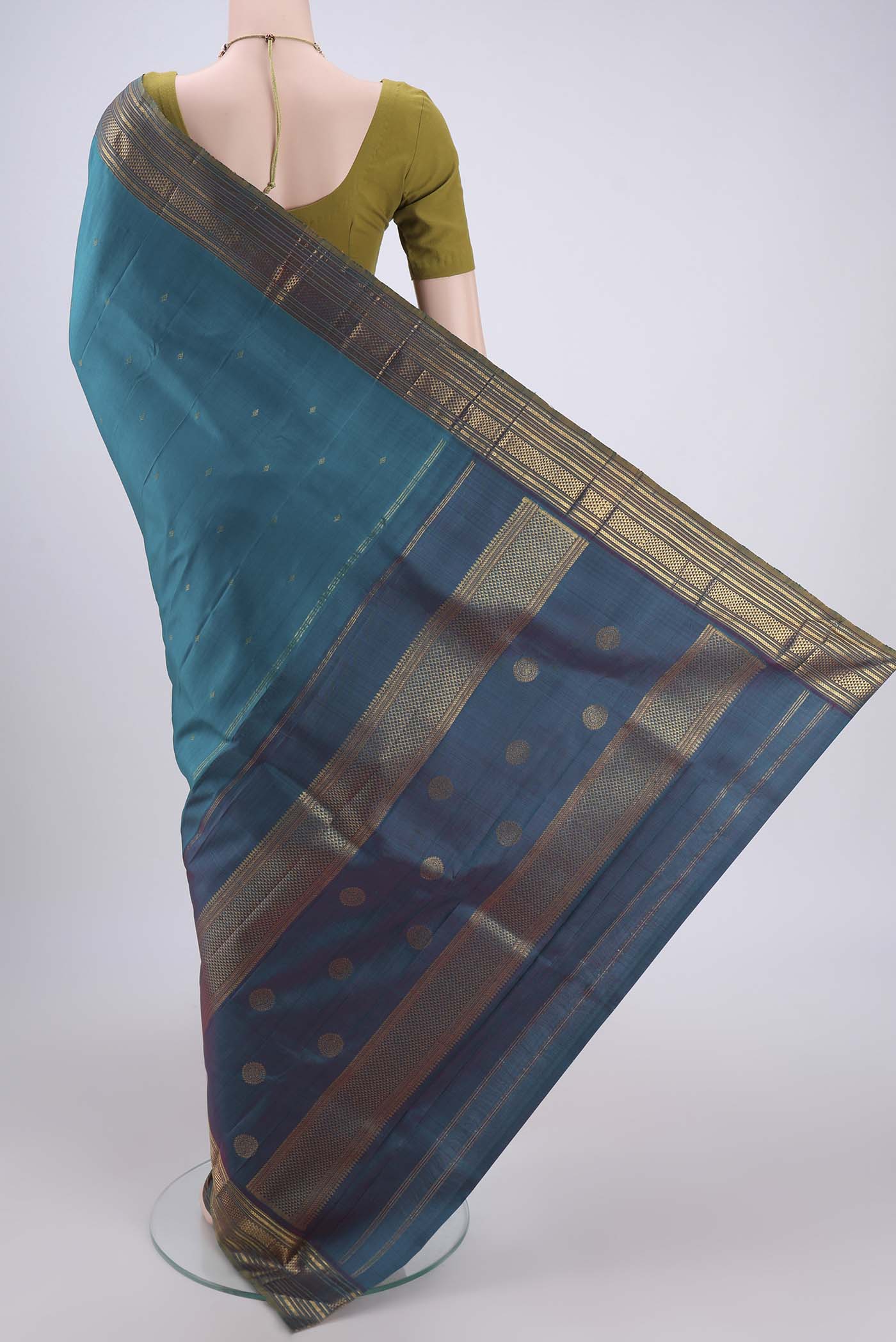 Flat view of Turquoise Kanchipuram Silk Saree with Zari Butta on the body and Zari Border. 