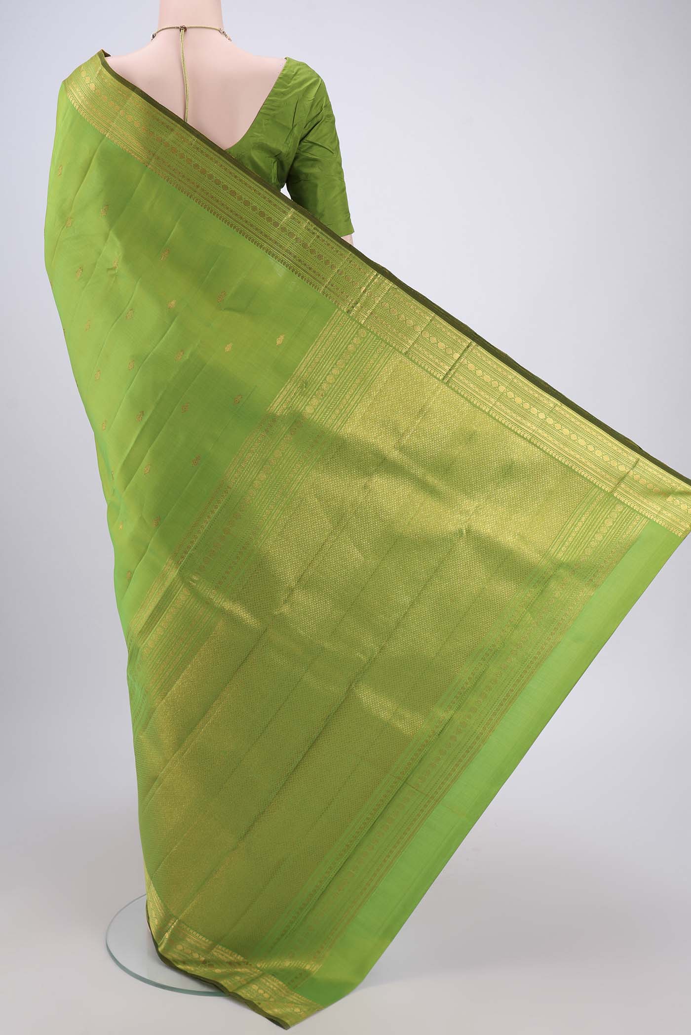 Flat view of Parrot Green Kanjivaram Silk Saree with Zari Butta on the body and Zari Border. 