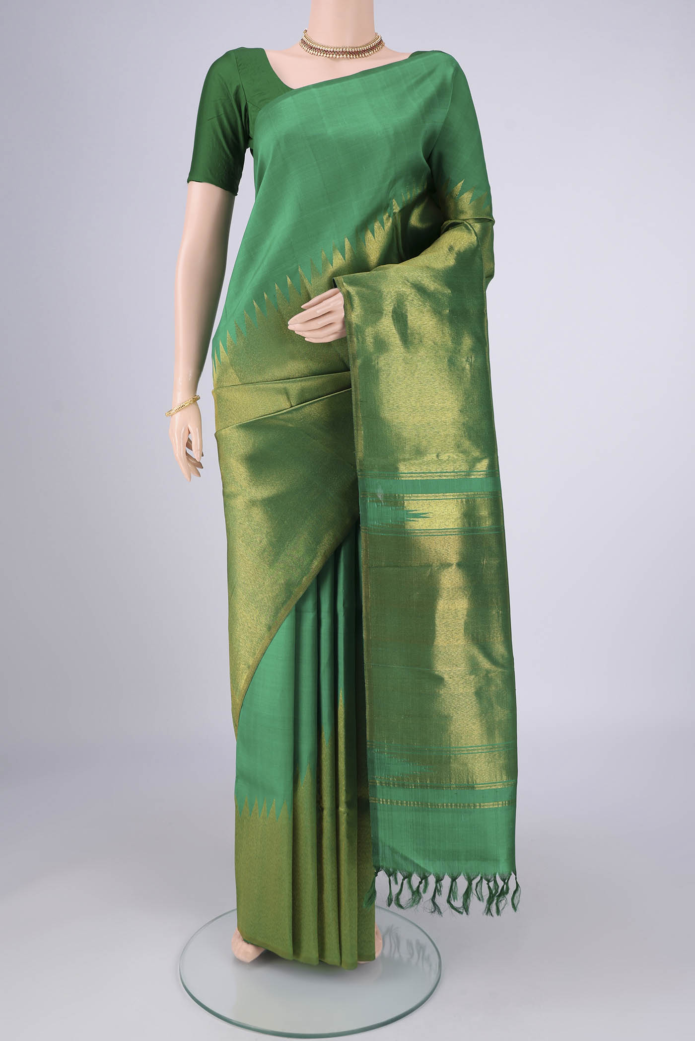Pure Silk Pure Zari Green Kanjivaram Saree with Plain Body and Rising Temple Border.  displayed on a mannequin