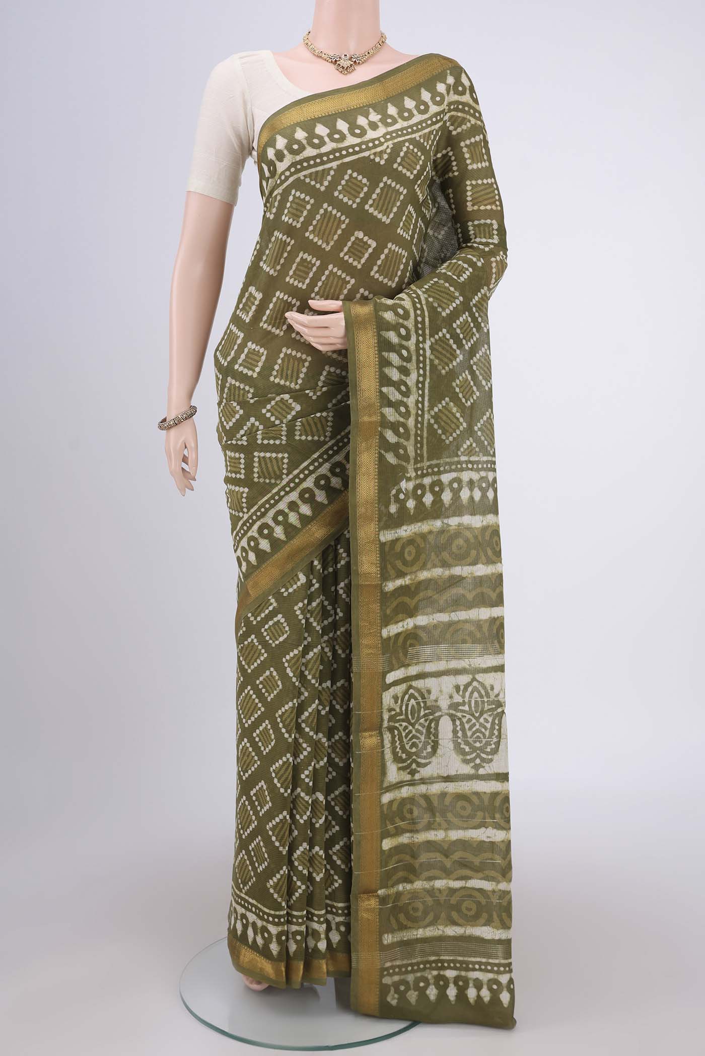 Mehandi Green Maheshwari Silk Cotton Saree with Batik Print on the body and Zari Border.  displayed on a mannequin