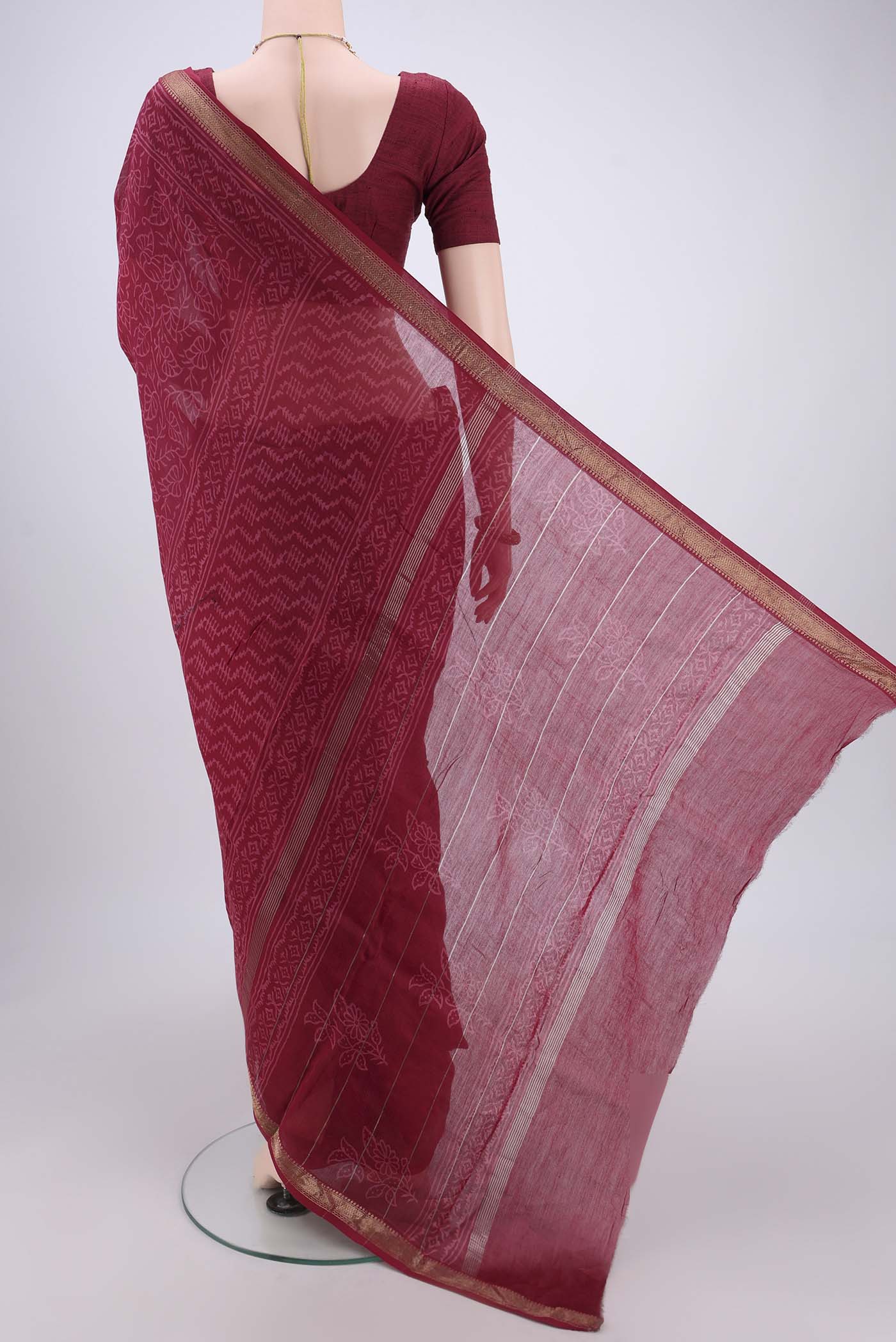 Flat view of Maroon Maheshwari Silk Cotton Saree with Printed design on the body and Zari Border. 