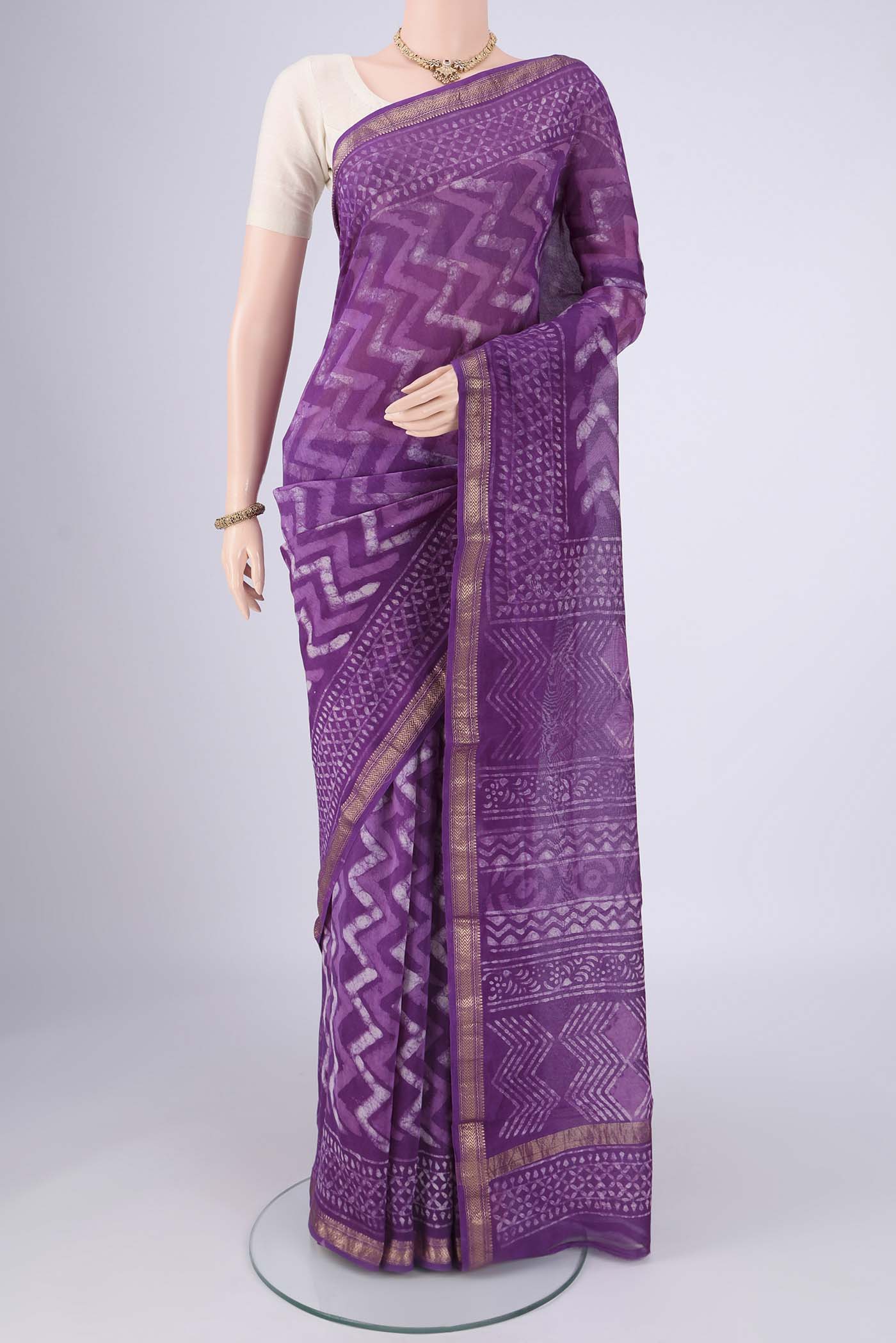 Magenta Maheshwari Silk Cotton Saree with Batik Print on the body and Zari Border.  displayed on a mannequin