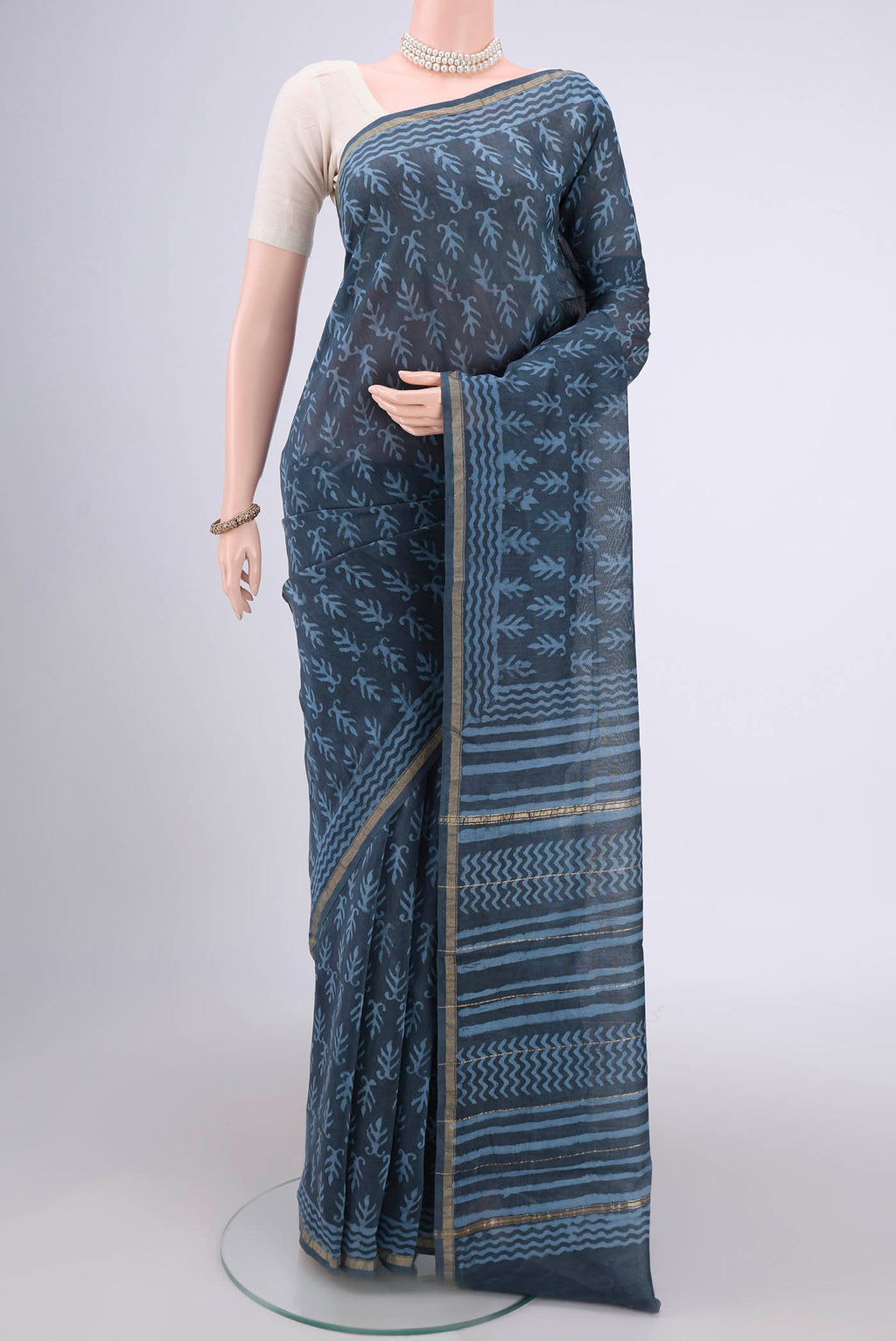 Blue Grey Maheshwari Silk Cotton Saree with Batik Print on the body and Zari Border.  displayed on a mannequin
