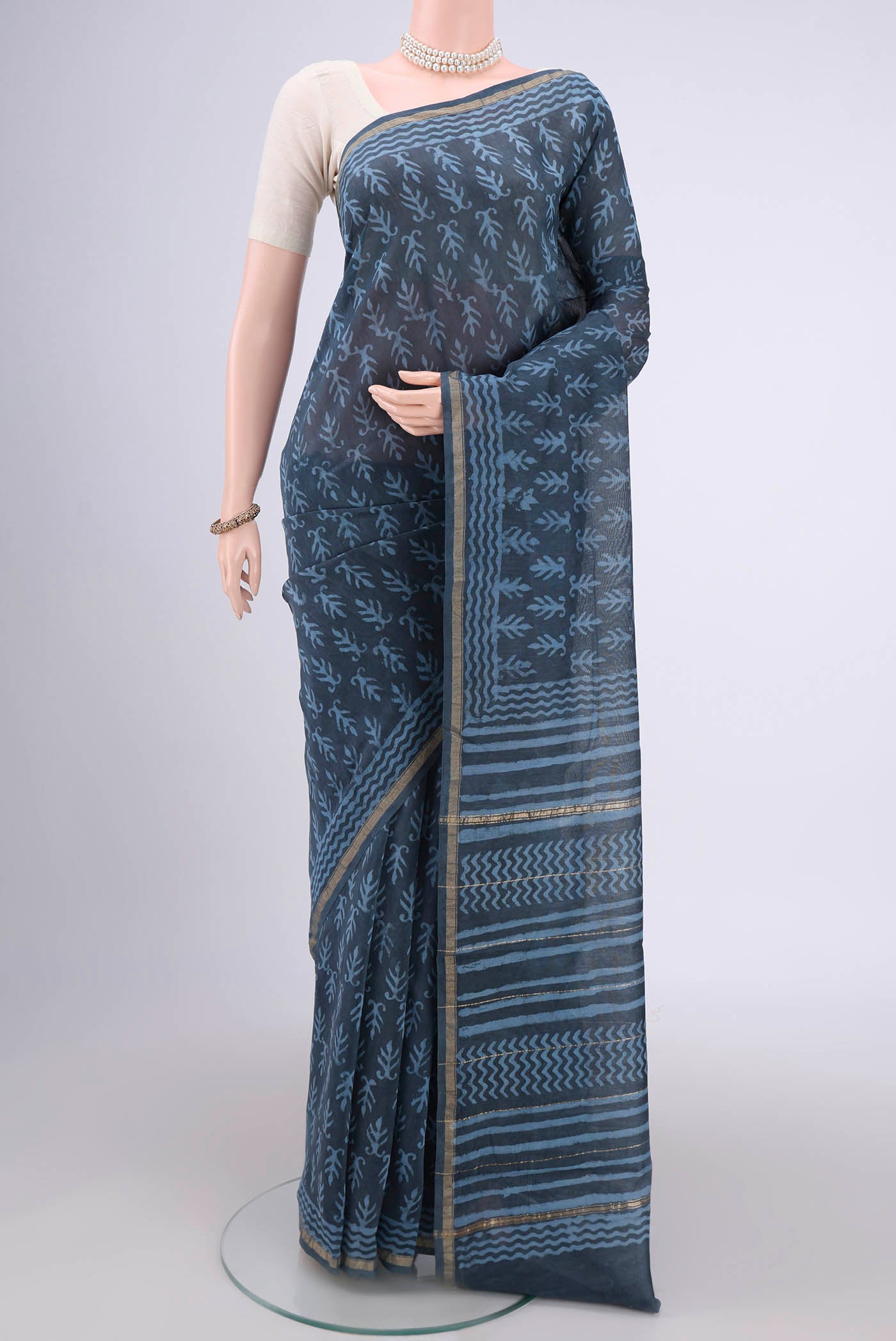 Blue Grey Maheshwari Silk Cotton Saree with Batik Print on the body and Zari Border.  displayed on a mannequin