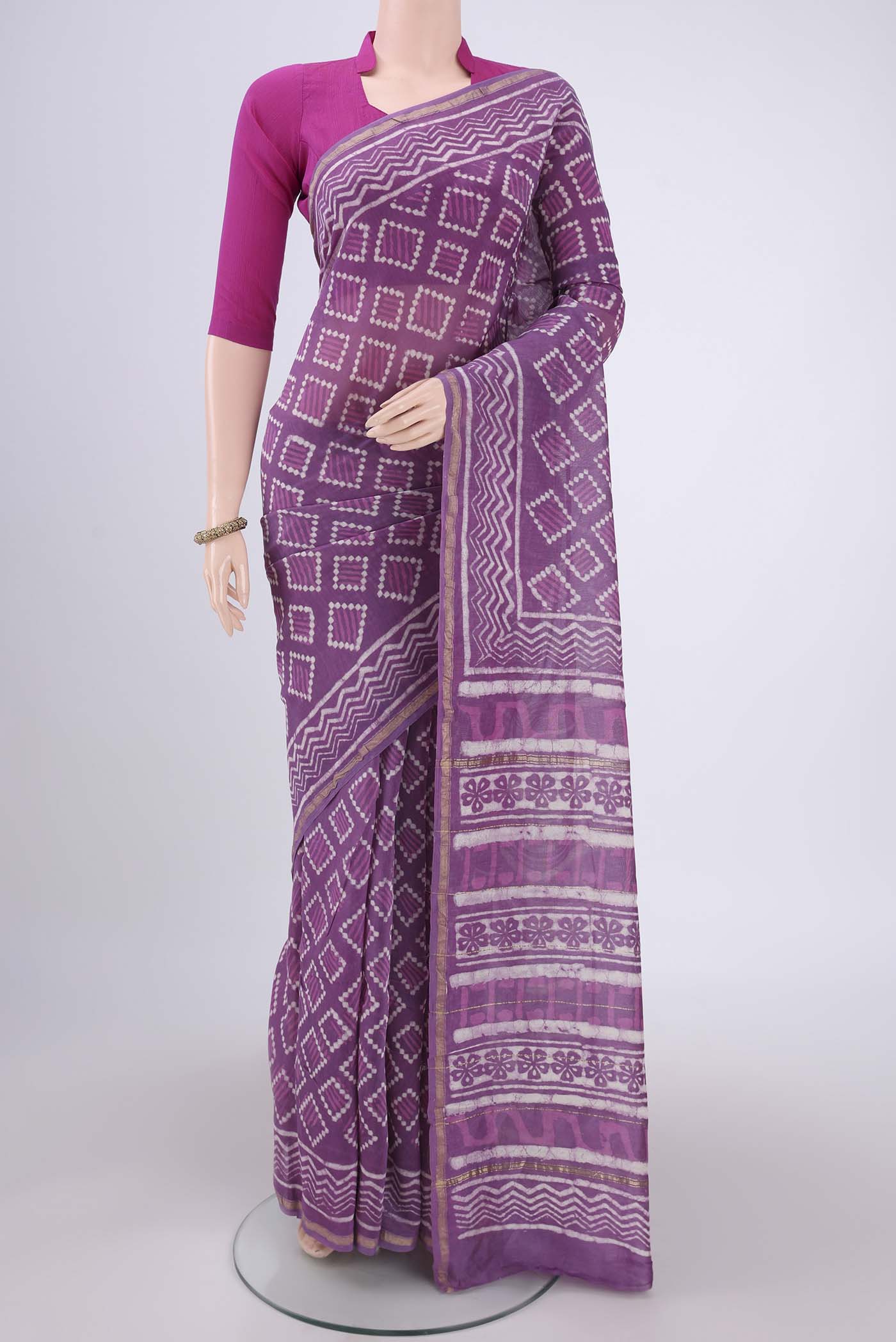 Violet Chanderi Silk Saree with Batik Print on the body and Zari Border.  displayed on a mannequin
