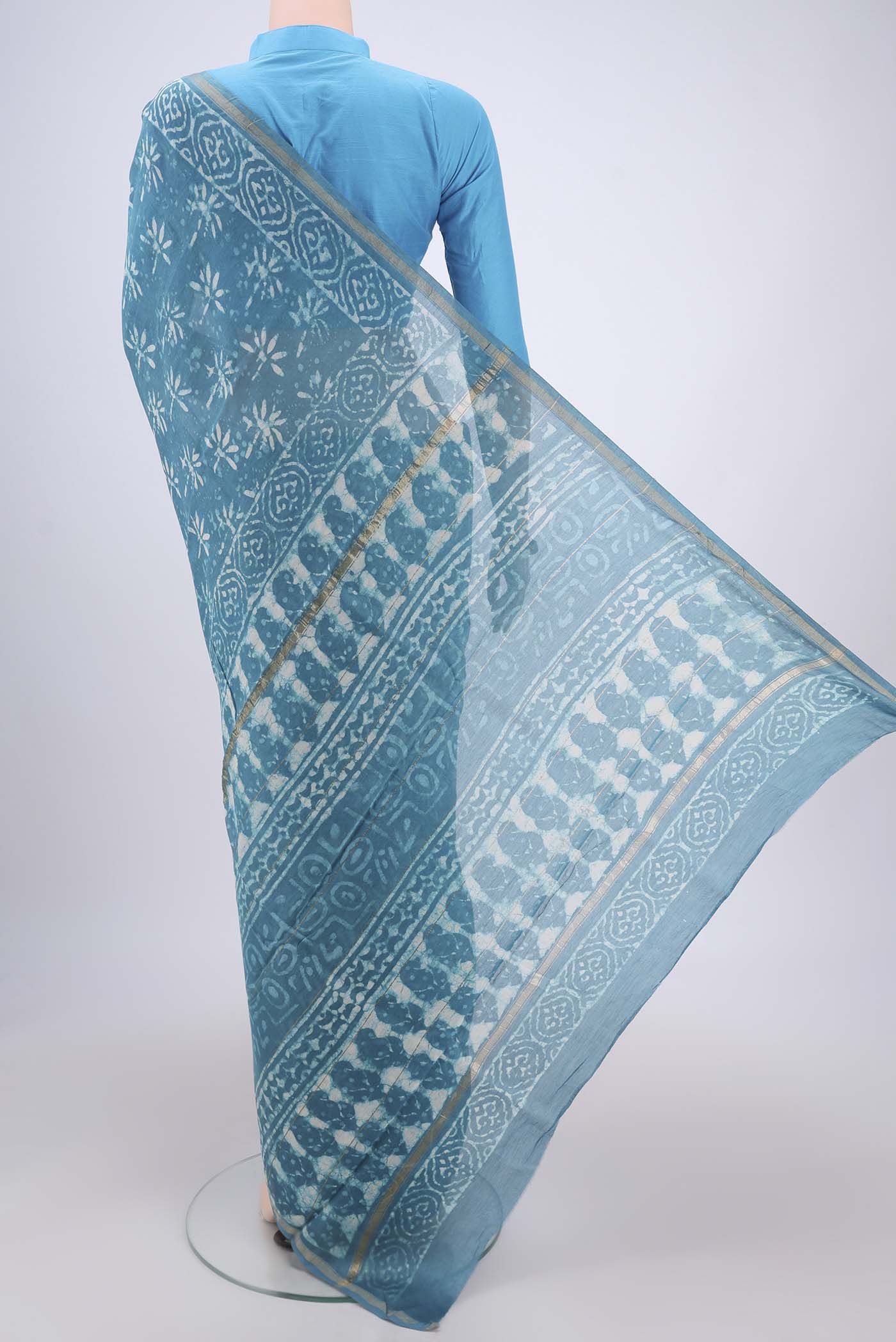 Flat view of Maya Blue Chanderi Silk Saree with Batik Print on the body and Zari Border. 