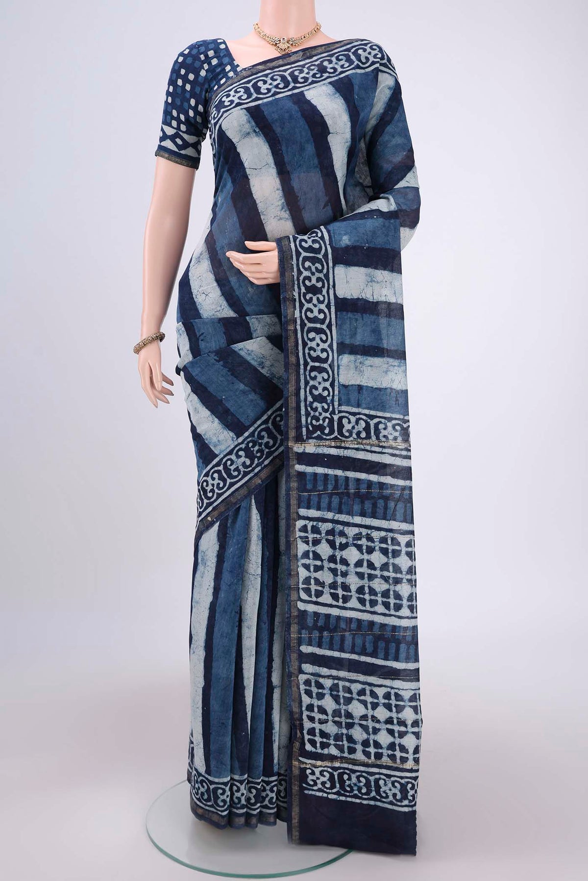 Indigo Chanderi Silk Saree with Batik Print on the body and Thin Zari Line.  displayed on a mannequin