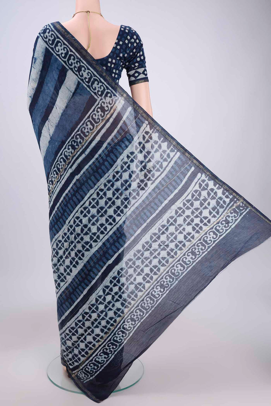 Flat view of Indigo Chanderi Silk Saree with Batik Print on the body and Thin Zari Line. 