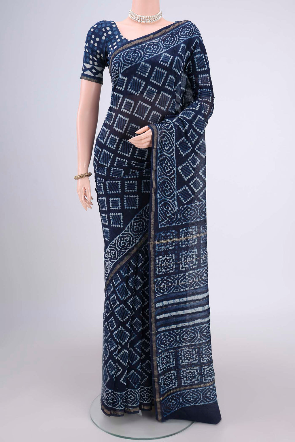 Indigo Maheshwari Silk Cotton Saree with Batik Print on the body and Zari Border.  displayed on a mannequin