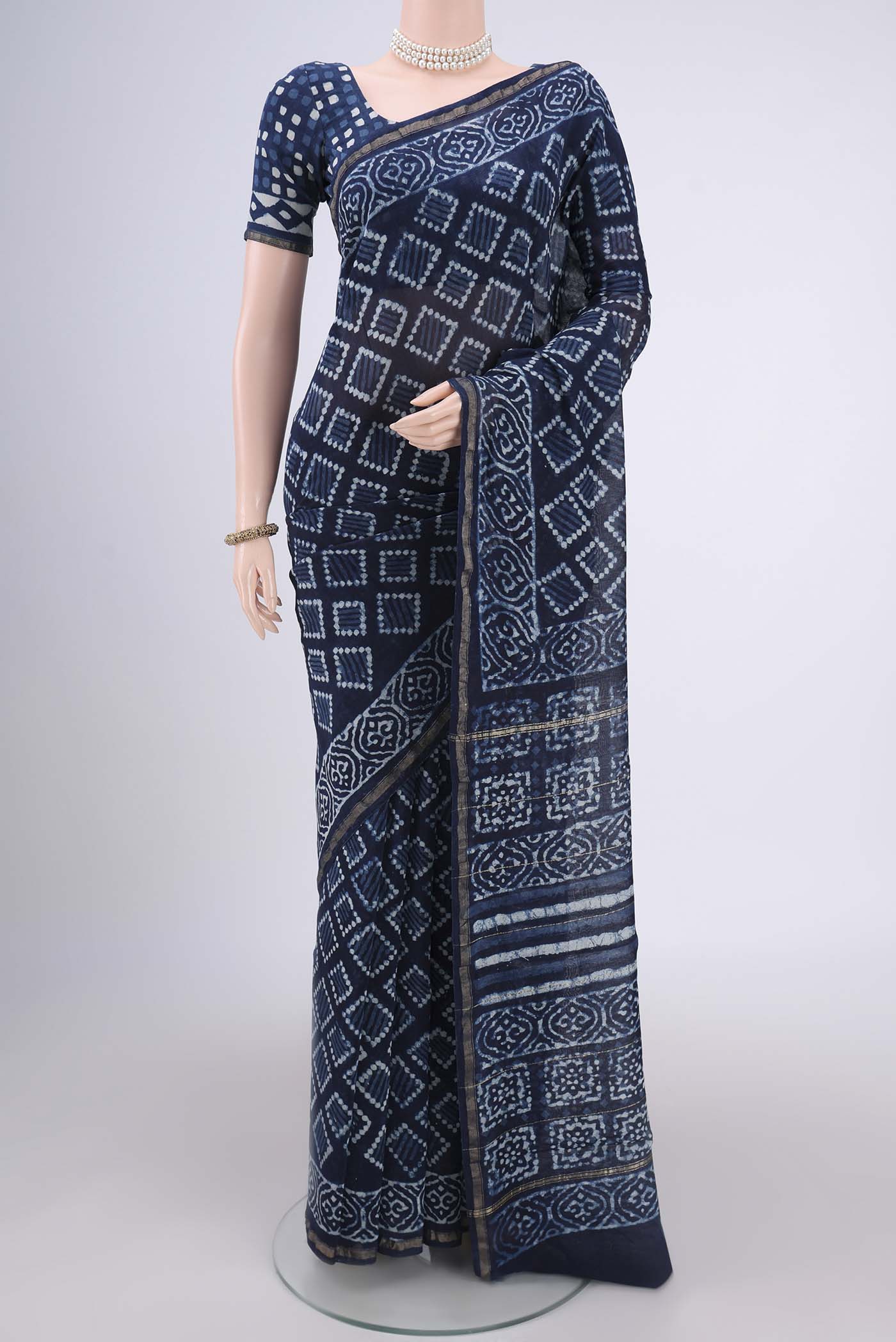 Indigo Maheshwari Silk Cotton Saree with Batik Print on the body and Zari Border.  displayed on a mannequin