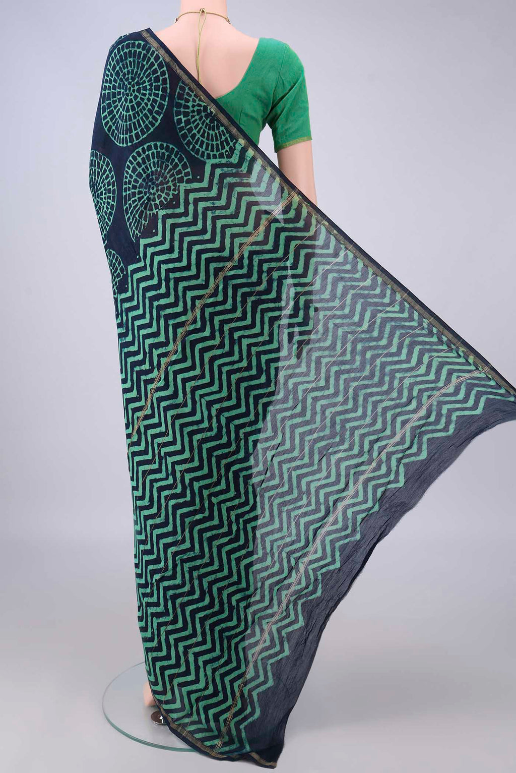 Flat view of Indigo Chanderi Cotton Saree with Batik Print on the body and Thin Zari Line. 