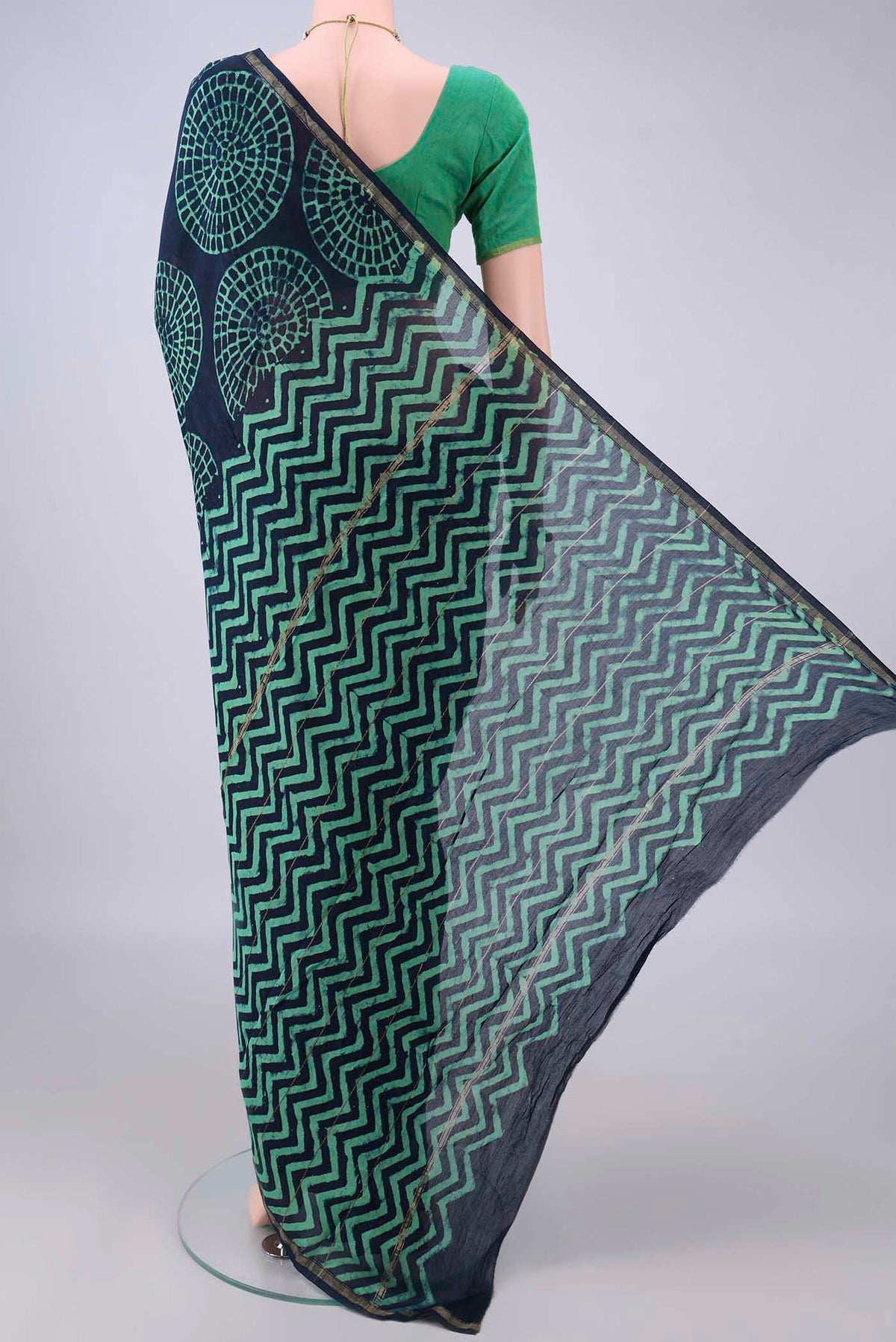Flat view of Indigo Chanderi Cotton Saree with Batik Print on the body and Thin Zari Line. 