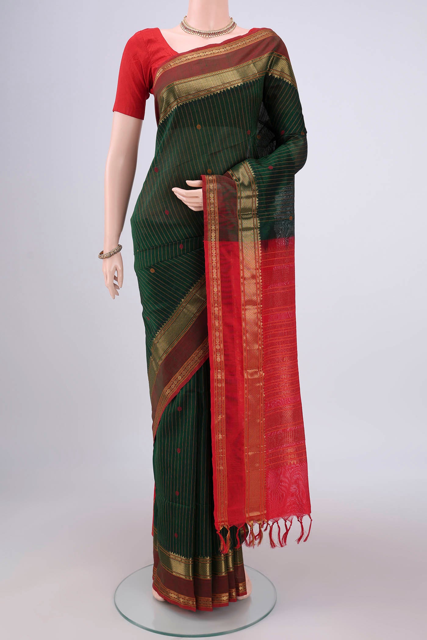 Bottle Green Coimbatore Silk Cotton Saree with Stripes on the body and Zari And Thread Border.  displayed on a mannequin