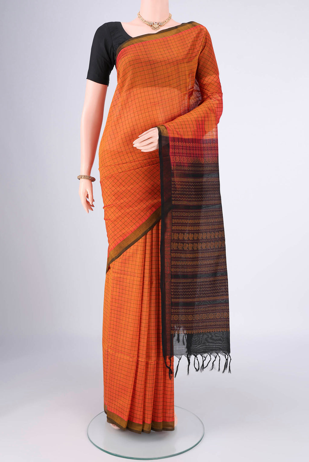 Rust Coimbatore Silk Cotton Saree with Checked design on the body and Plain Border.  displayed on a mannequin
