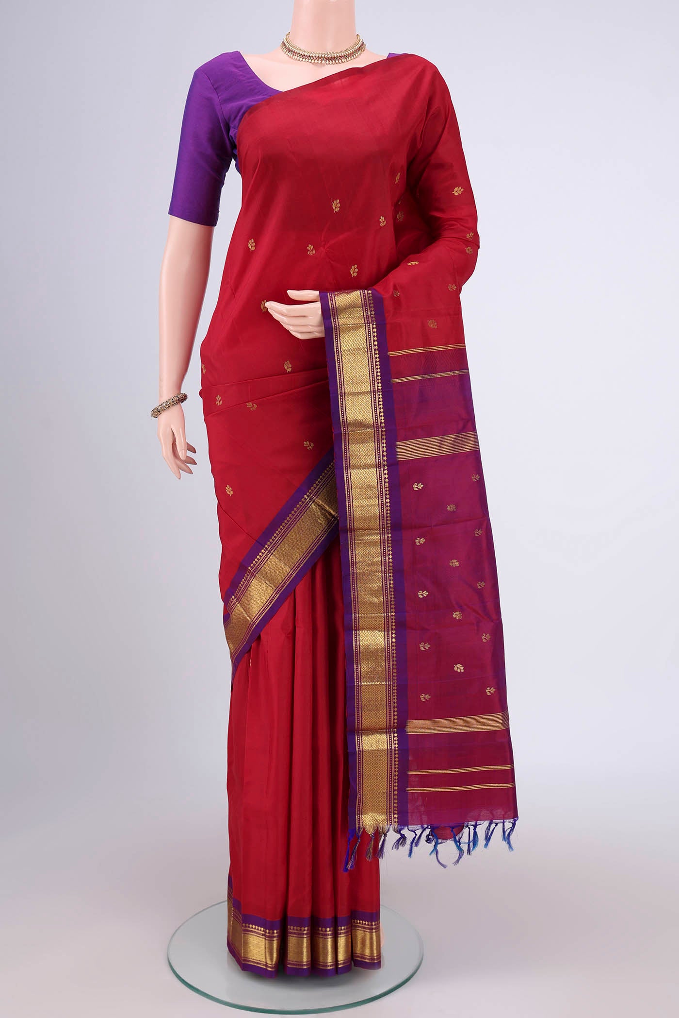 Maroon Kanjivaram Silk Saree with Plain Body and One Side Border.  displayed on a mannequin