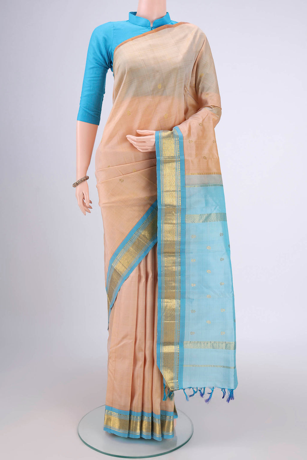 Cream Kanjivaram Silk Saree with Zari Butta on the body and One Side Border.  displayed on a mannequin