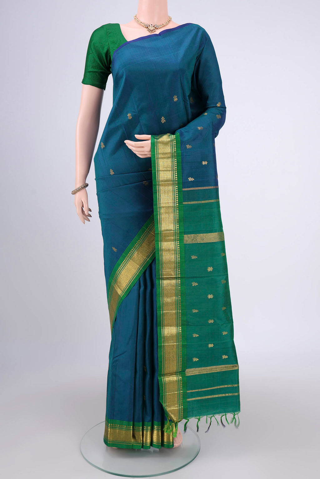Peacock Blue Kanjivaram Silk Saree with Zari Butta on the body and One Side Border.  displayed on a mannequin