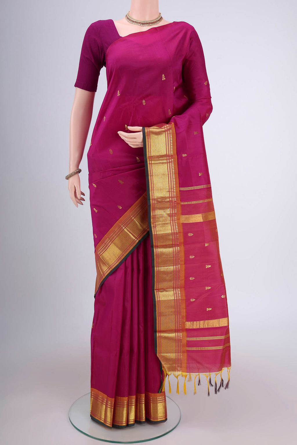Magenta Kanjivaram Silk Saree with Plain Body and One Side Border.  displayed on a mannequin