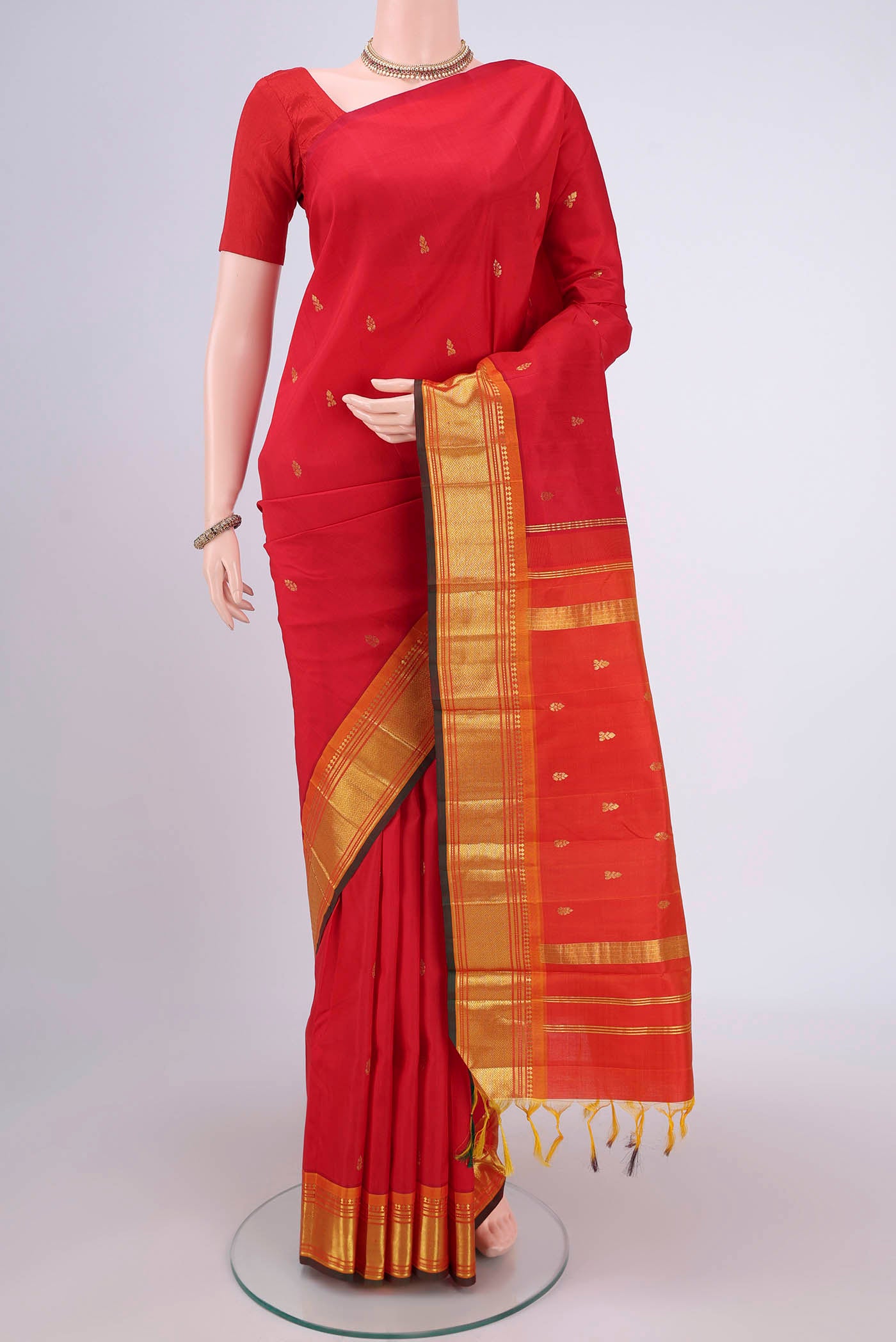 Red Kanjivaram Silk Saree with Zari Butta on the body and One Side Border.  displayed on a mannequin
