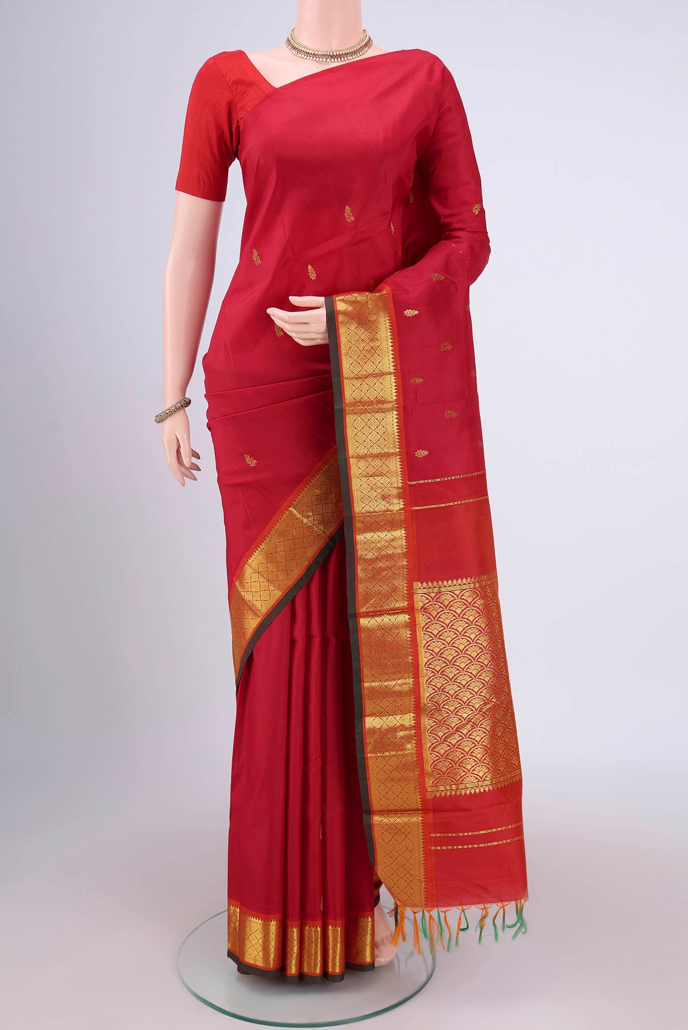 Red Kanjivaram Silk Saree with Zari Butta on the body and One Side Border.  displayed on a mannequin