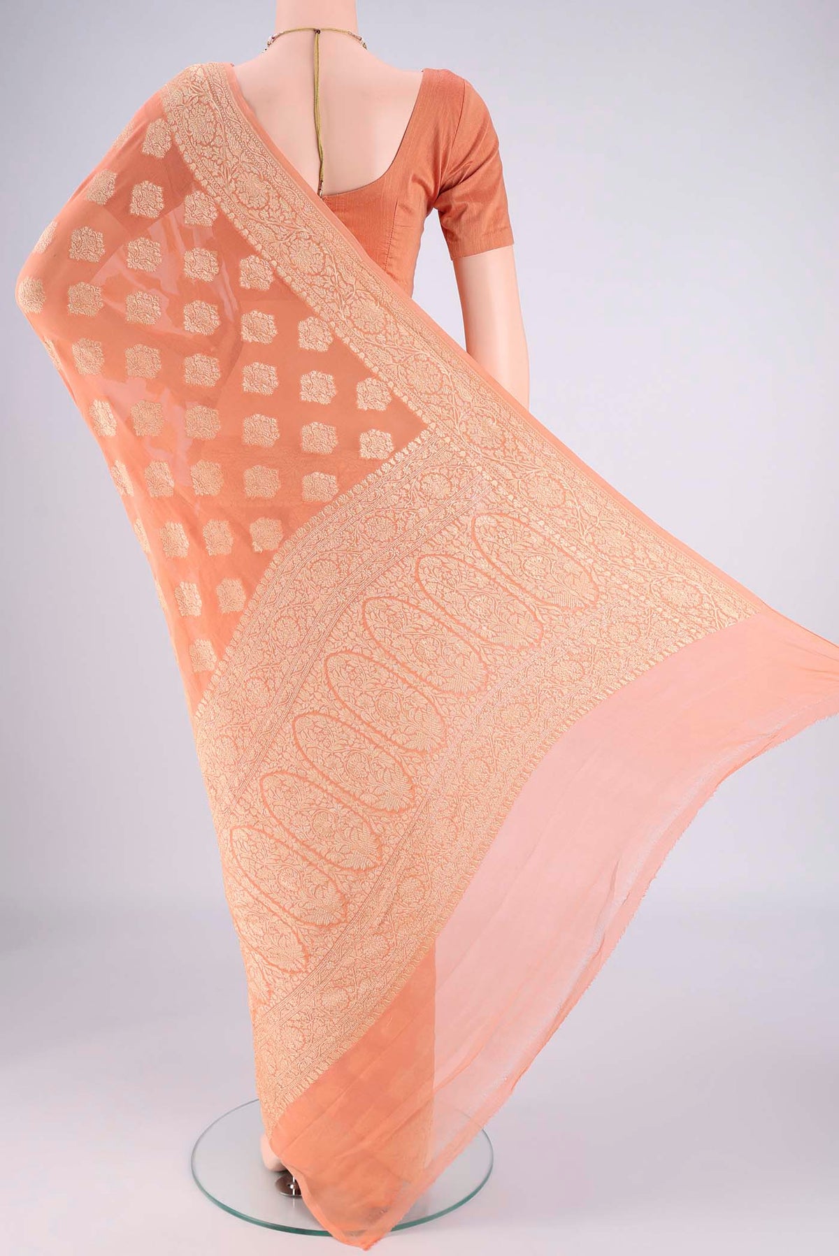Flat view of Peach Banarasi Georgette Saree with Zari Butta on the body and Zari Border. 