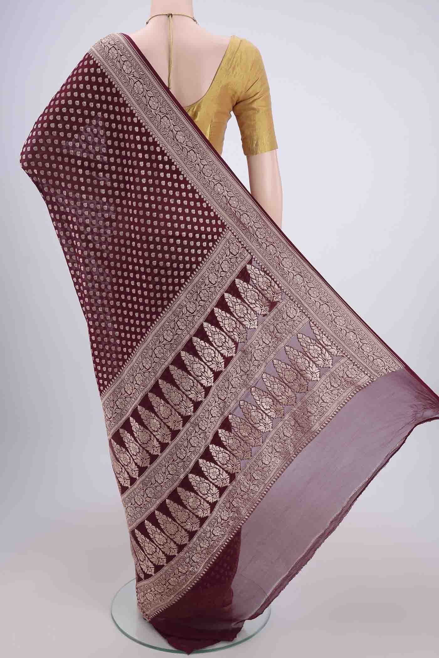 Flat view of Maroon Banarasi Georgette Saree with Zari Butta on the body and Zari Border. 