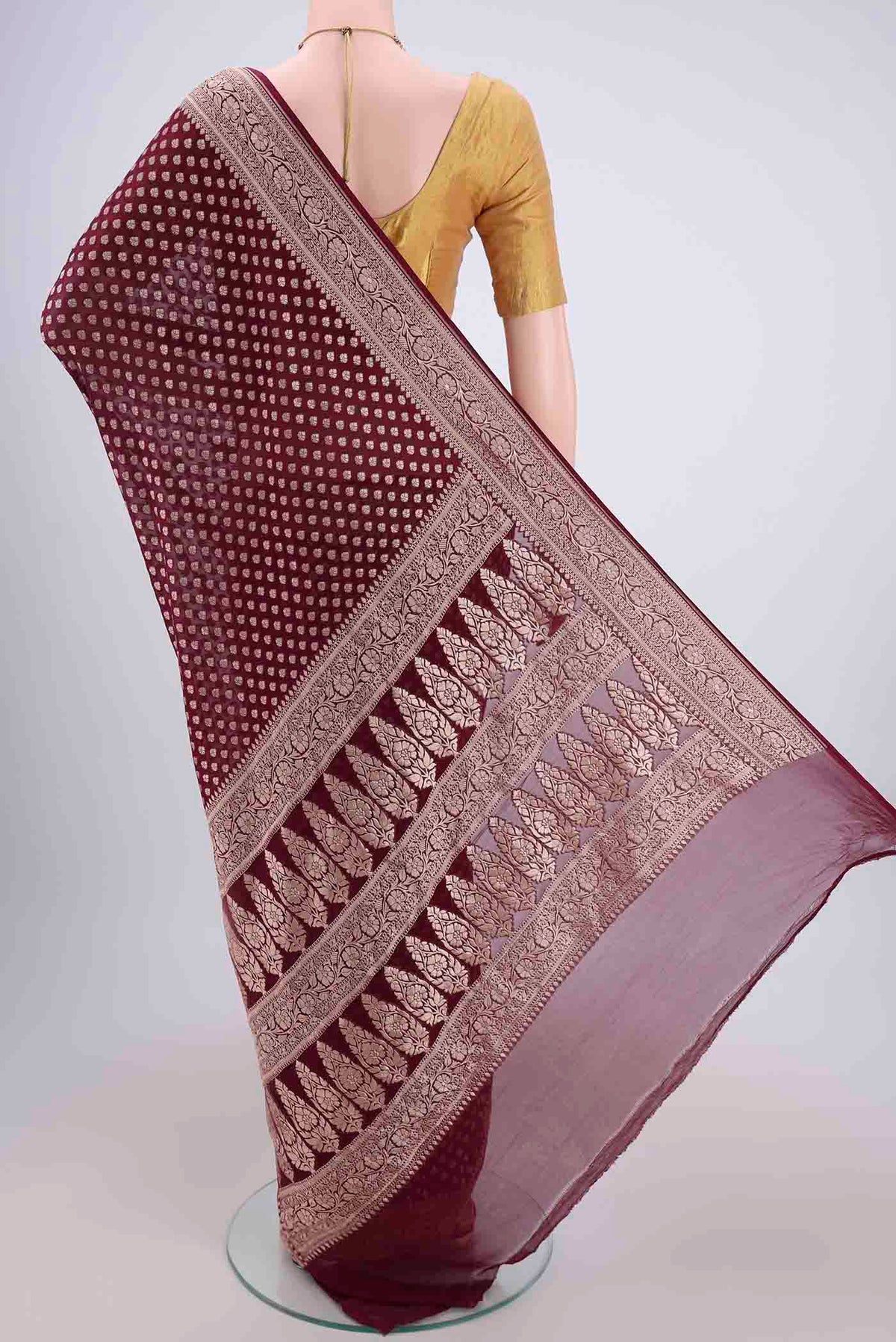 Flat view of Maroon Banarasi Georgette Saree with Zari Butta on the body and Zari Border. 