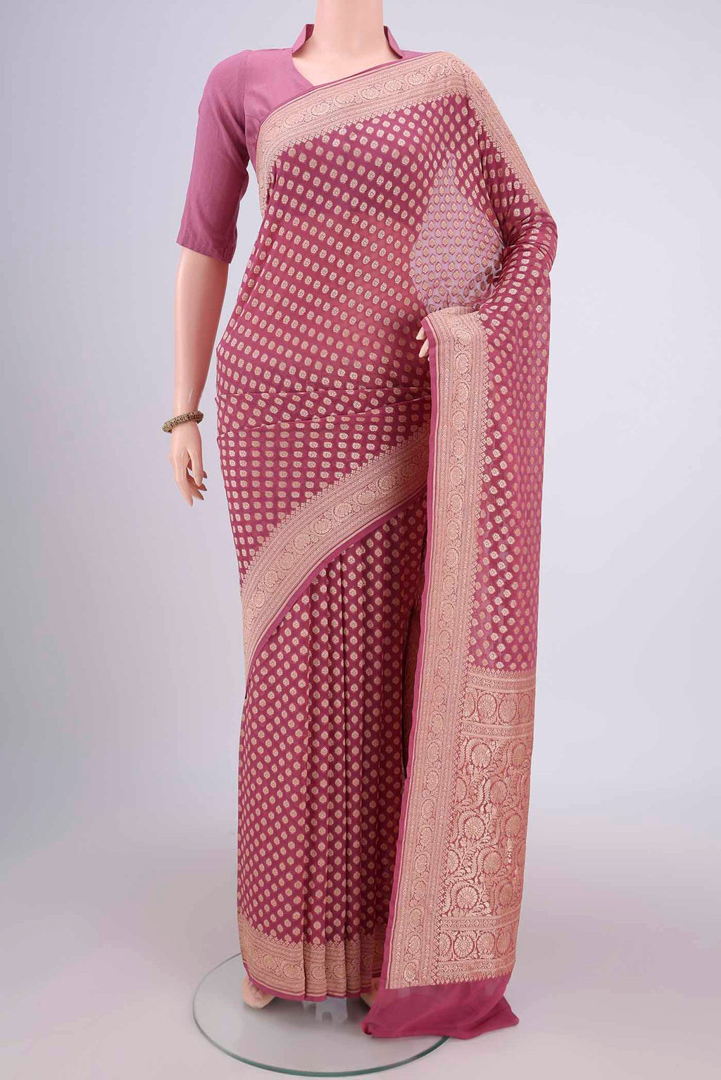 Rose Gold Banarasi Georgette Saree with Zari Brocade on the body and Zari Border.  displayed on a mannequin