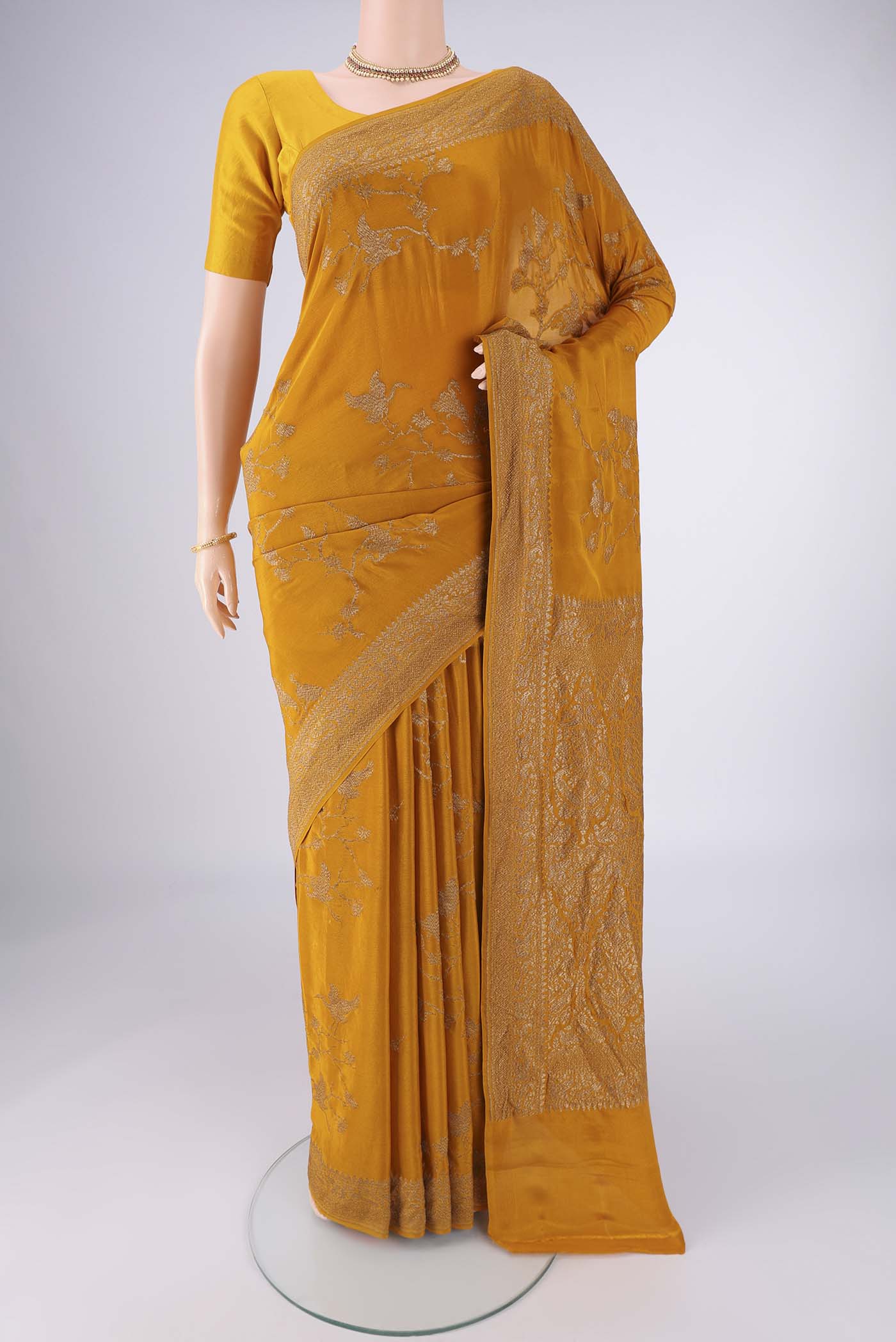 Mustard Banarasi Georgette Saree with Zari Brocade on the body and Zari Border.  displayed on a mannequin