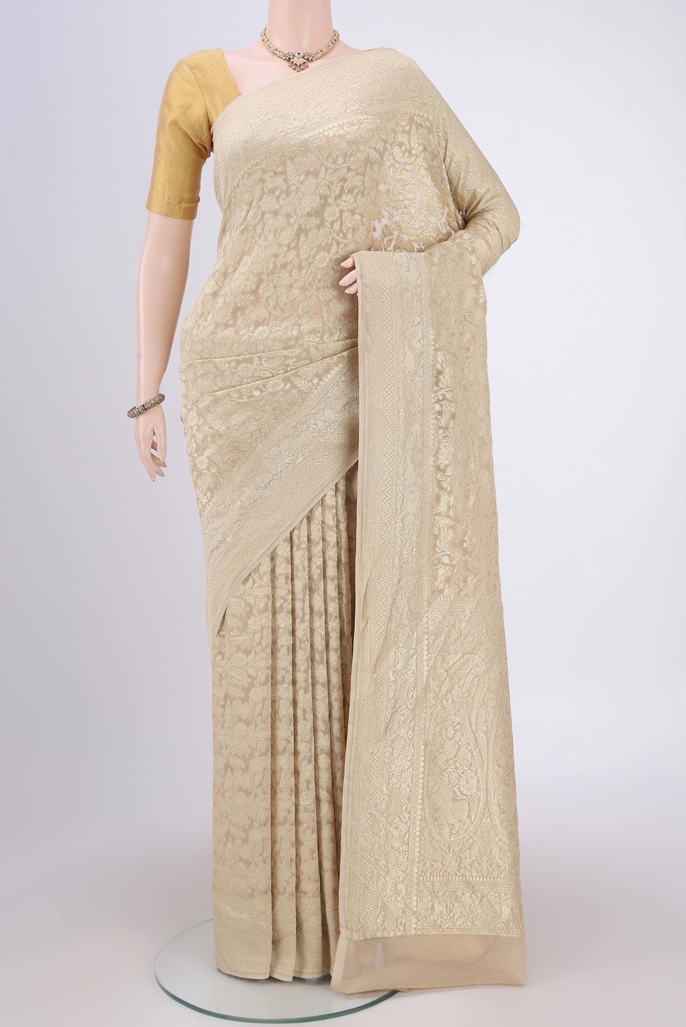 Beige Banarasi Georgette Saree with Zari Brocade on the body and Zari Border.  displayed on a mannequin
