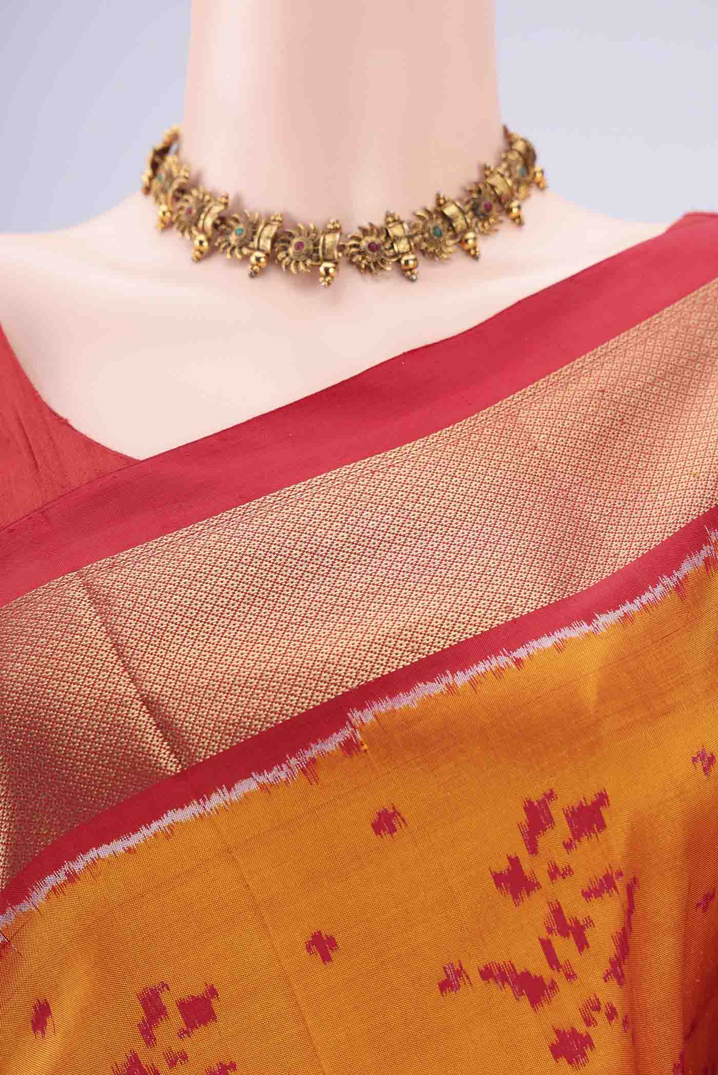 Border image of Orange Pochampally Silk Saree with Ikat design on the body and Zari Border. 