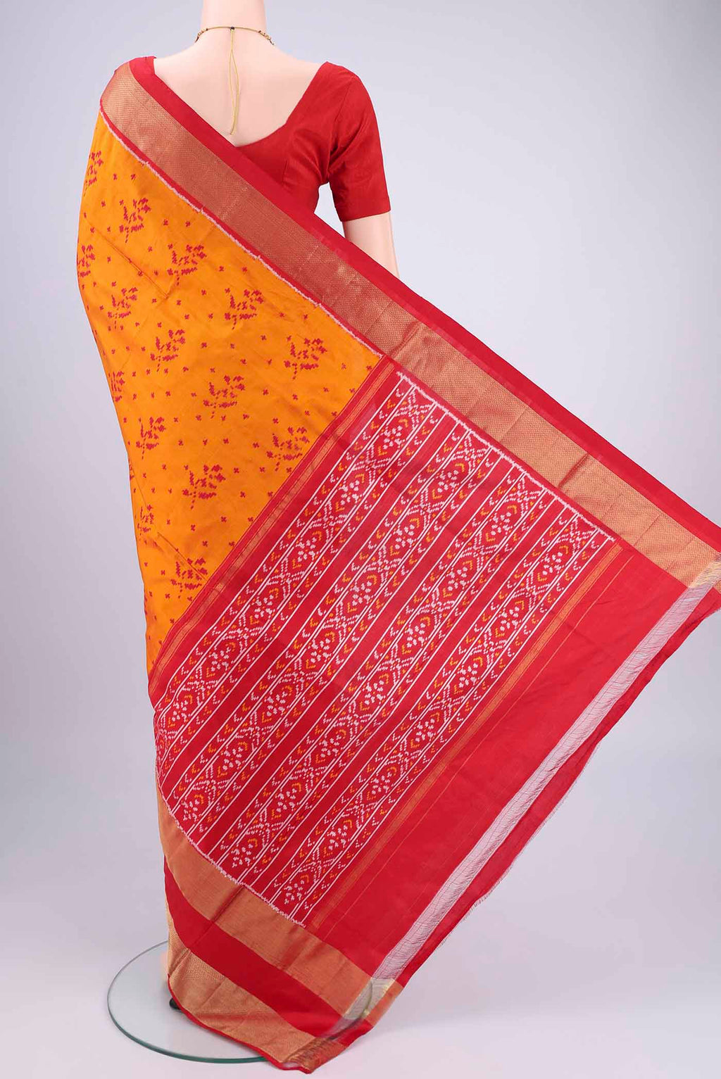 Flat view of Orange Pochampally Silk Saree with Ikat design on the body and Zari Border. 