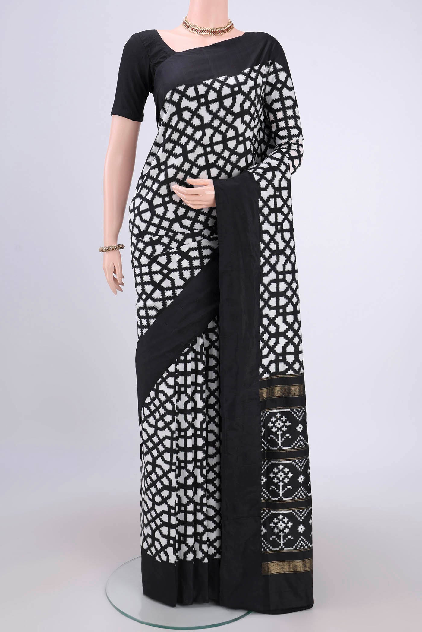 White Pochampally Silk Saree with Ikat design on the body and Zari Border.  displayed on a mannequin