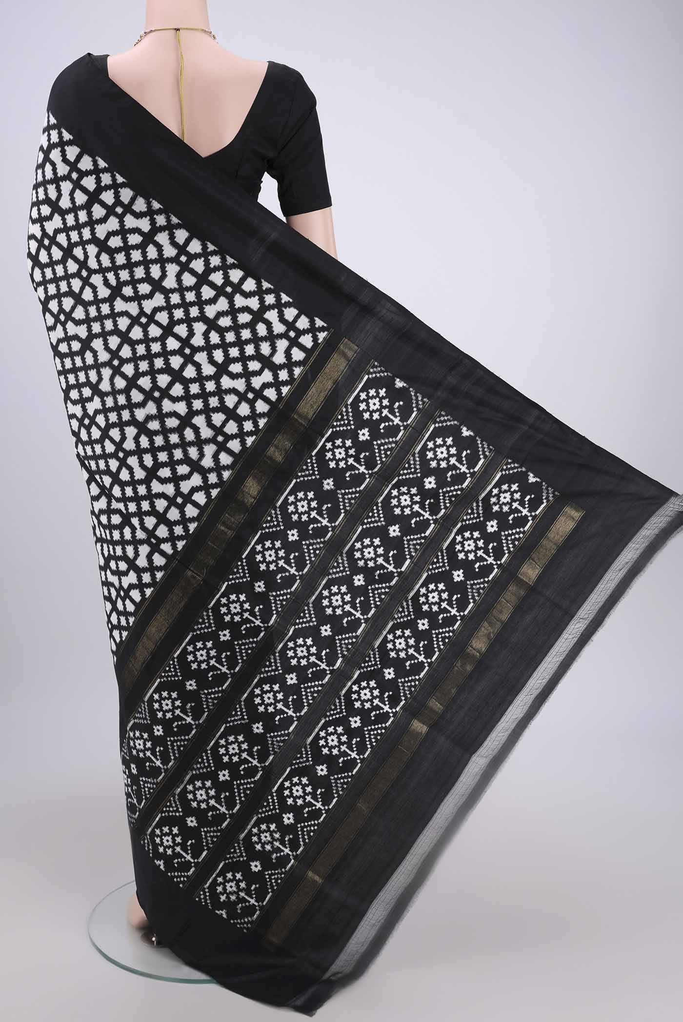 Flat view of White Pochampally Silk Saree with Ikat design on the body and Zari Border. 