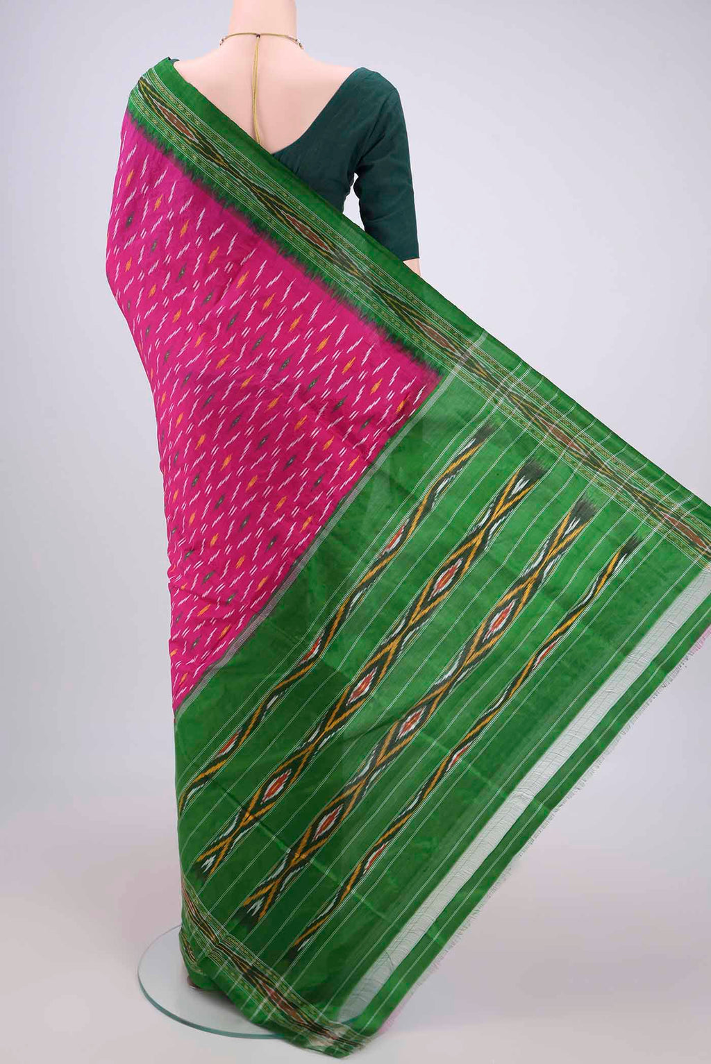 Flat view of Rani Pink Pochampally Silk Saree with Ikat design on the body and Plain Border. 